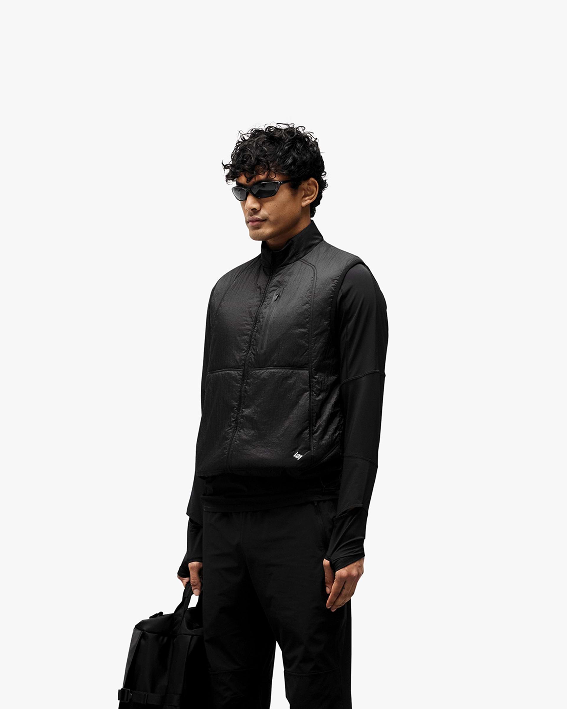 Man wearing a black gilet on a plain white background | 247 Run Gilet in Black | Performance running gilet with insulation and breathable mesh | 247 Outerwear | Represent Clo