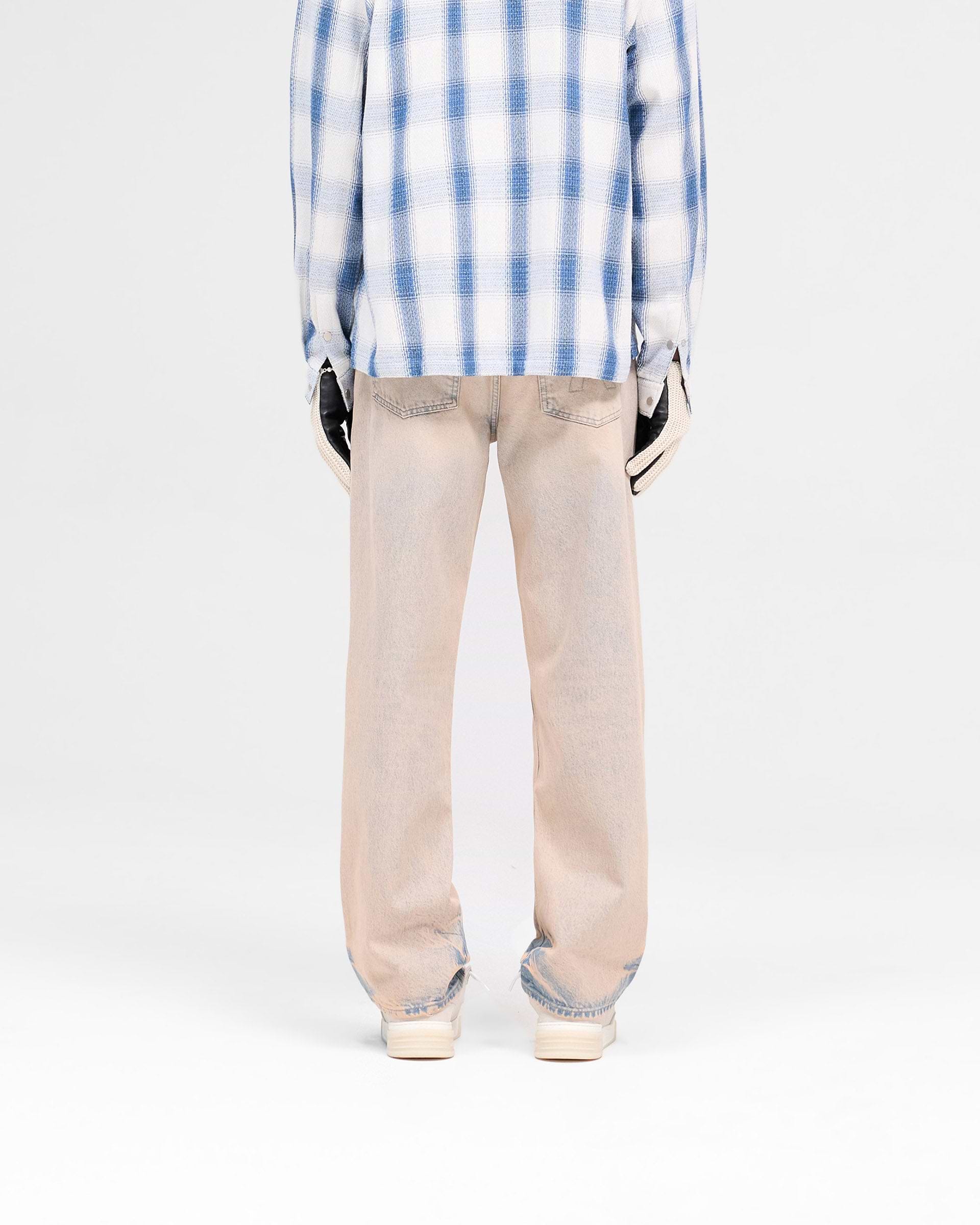 Man wearing baggy blue denim jeans on a plain white background | R3 Baggy Denim in Dusk | Baggy fit heavy wash denim jeans | SS25 Denim | Represent Clo