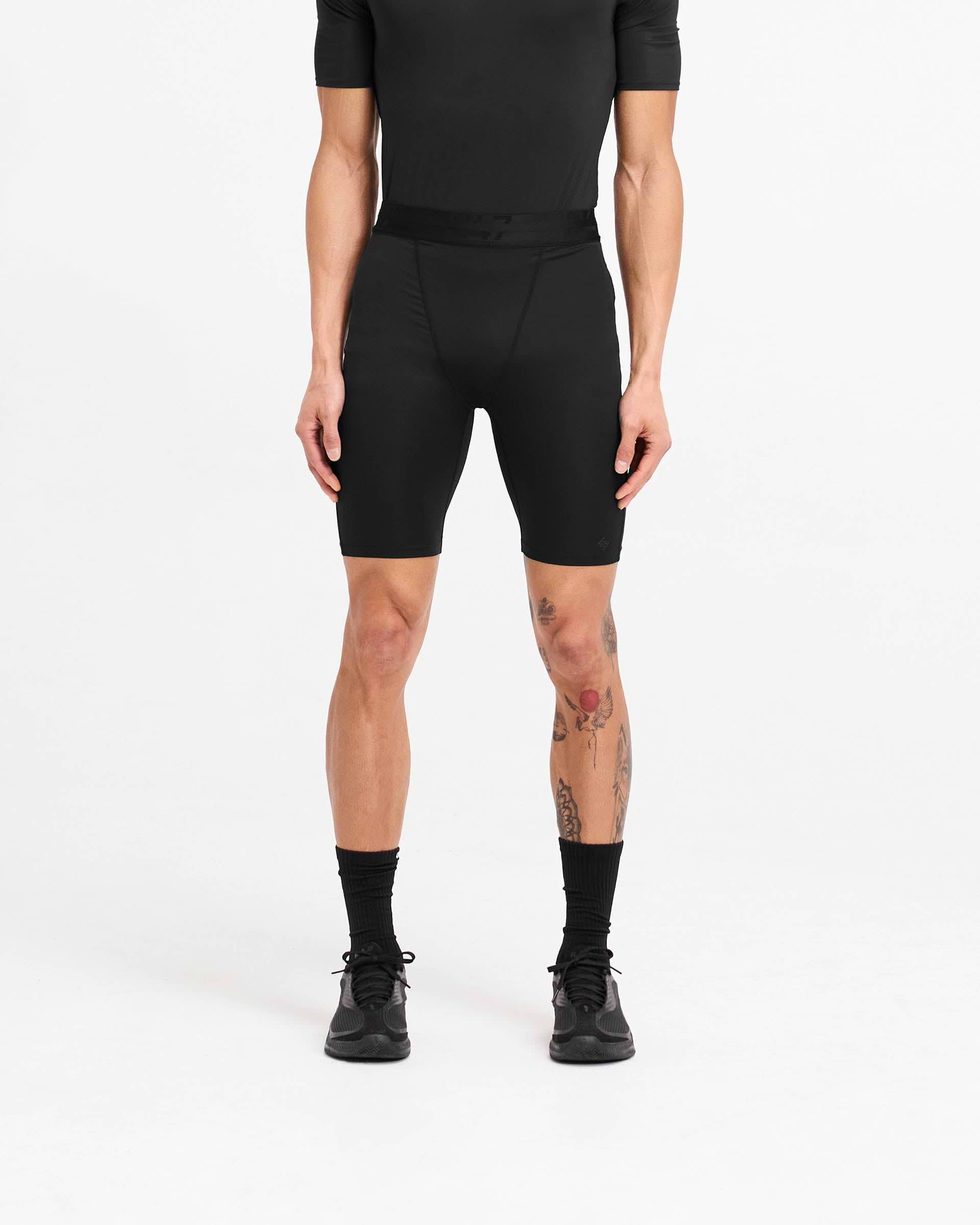 Man wearing black legging shorts on a plain white background | 247 Compound Legging Short in Black | Training shorts with branded waistband and fused pocket | 247 Shorts | Represent Clo