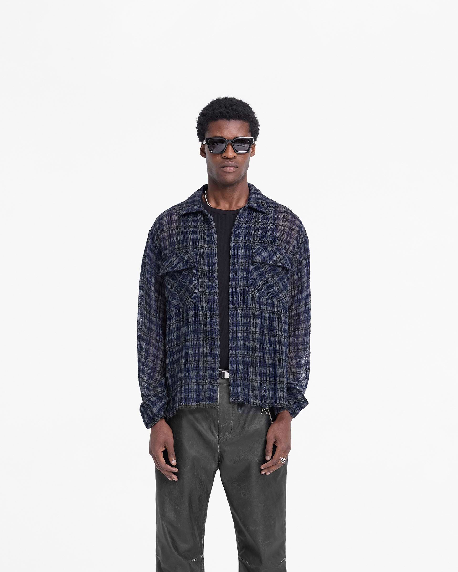 Man wearing a blue check flannel shirt on a plain white background | Check Flannel Shirt in Blue Check | Slightly oversized flannel shirt with flap pockets | FW24 Shirts | Represent Clo