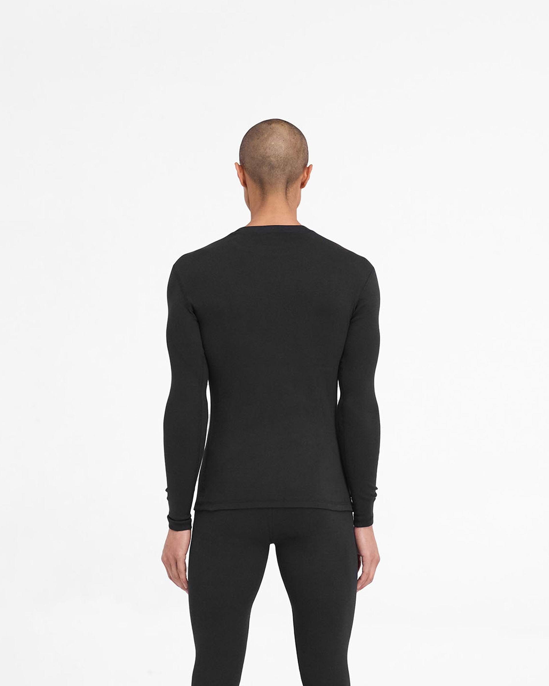 Man wearing a ribbed black long sleeve top on a plain white background | 247 Ribbed Long Sleeve Top in Black | Thermal base layer with close fit | 247 T-Shirts | Represent Clo