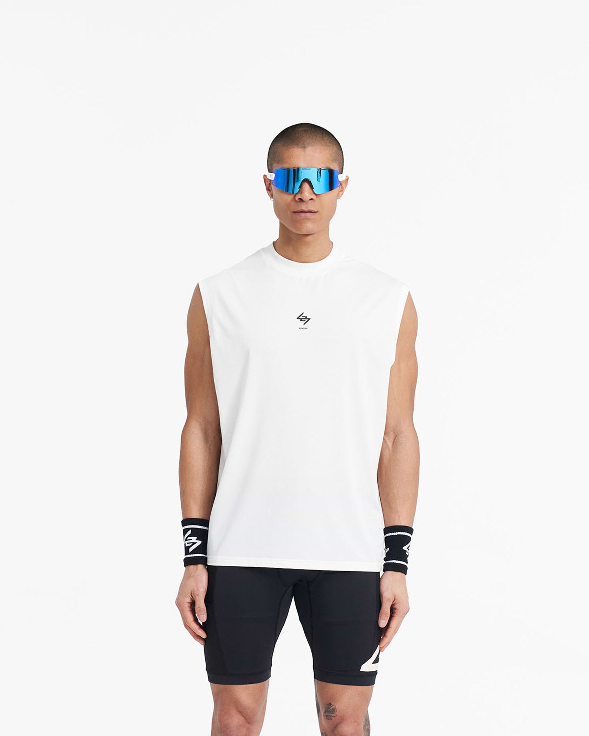 Man wearing a white oversized tank on a plain white background | 247 Oversized Tank in Flat White | Lightweight breathable tank with 4-way stretch | 247 T-Shirts | Represent Clo