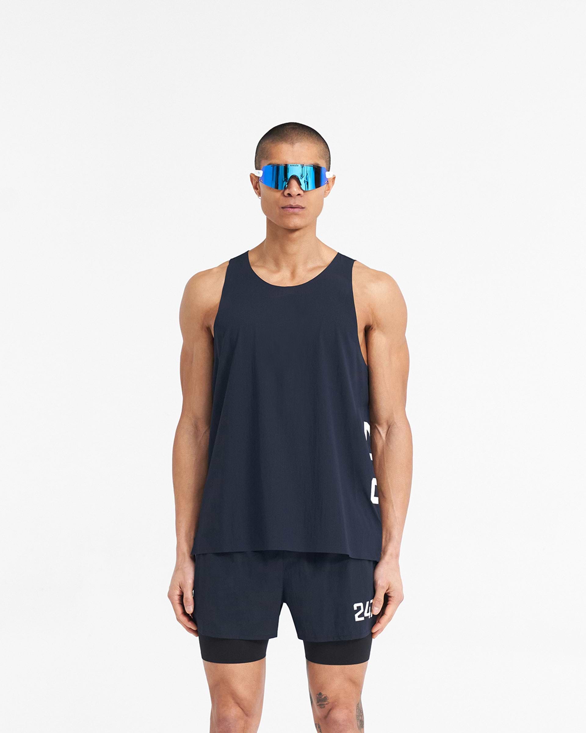 Man wearing a navy singlet on a plain white background | 247 Singlet in Navy | Training vest with stretch ripstop fabric and bonded hems | 247 T-Shirts | Represent Clo