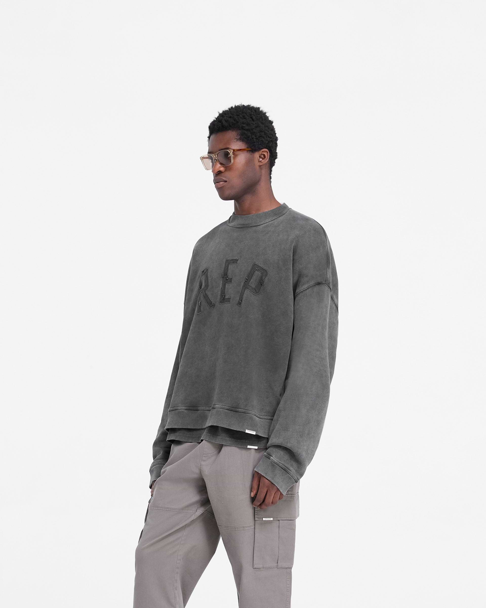 Back product image of a mens black sweater on a plain white background | Rep Applique Sweater in Vintage Black | Oversized heavyweight cotton sweater with ribbed hem and cuffs | FW24 Sweaters | Represent Clo