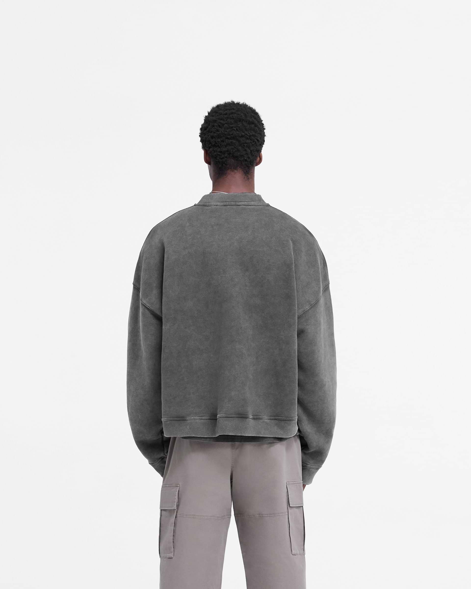 Man wearing an oversized black sweater on a plain white background | Rep Applique Sweater in Vintage Black | Heavy weight jersey cotton boxy sweater | FW24 Sweaters | Represent Clo