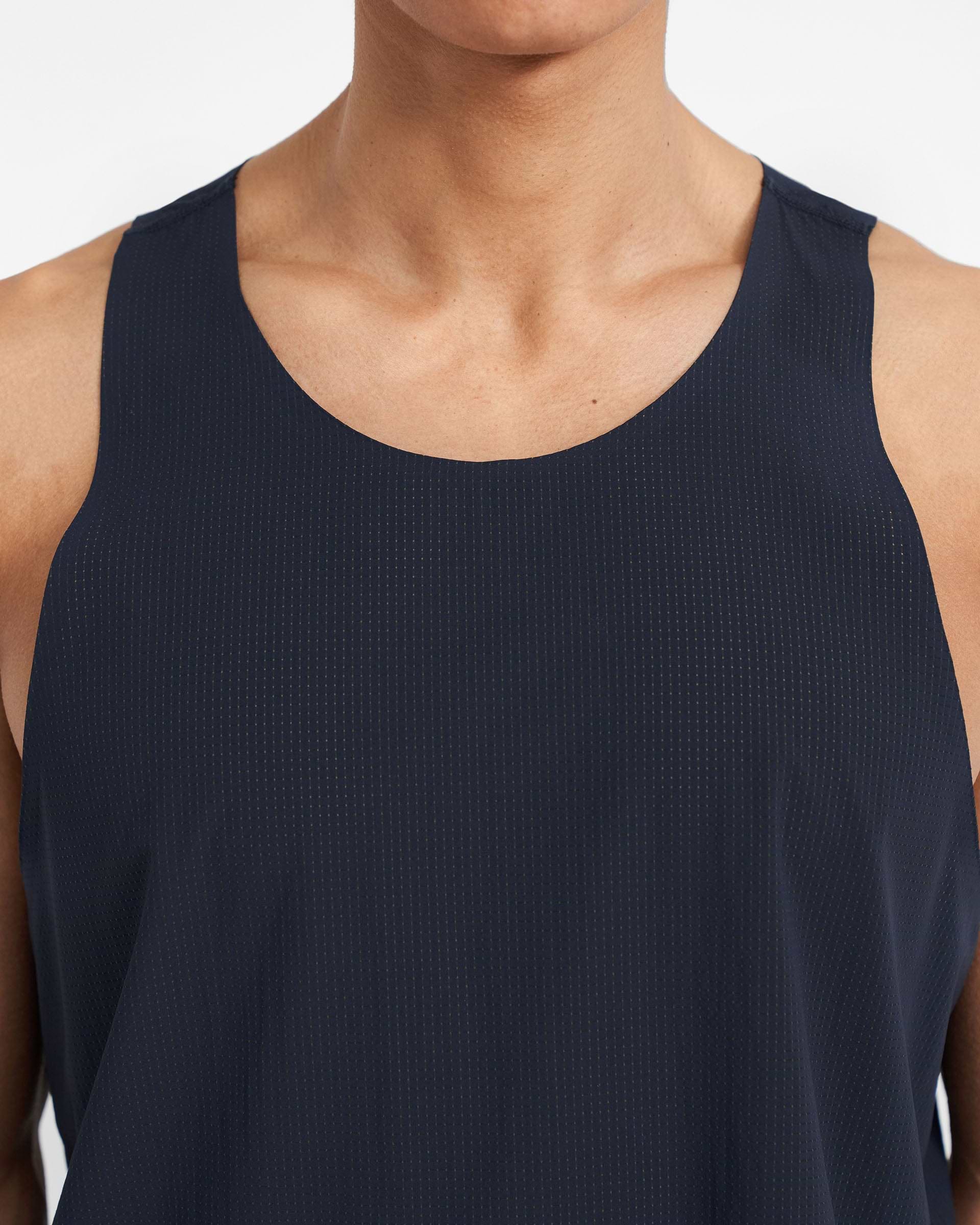 Man wearing a navy training vest on a plain white background | 247 Singlet in Navy | Perforated singlet with bonded hems | 247 T-Shirts | Represent Clo