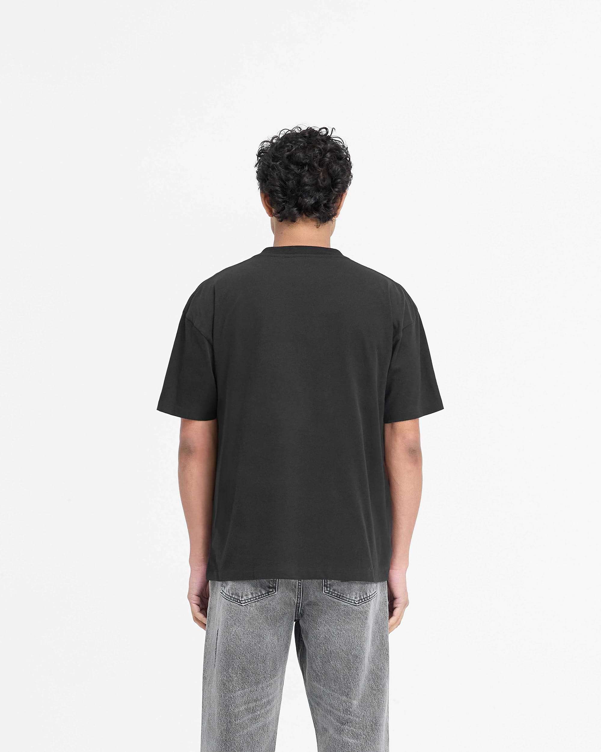 Man wearing a black t-shirt on a plain white background | Serif Logo T-Shirt in Jet Black | Slightly oversized t-shirt with embroidered branding | PRE SS25 T-Shirts | Represent Clo
