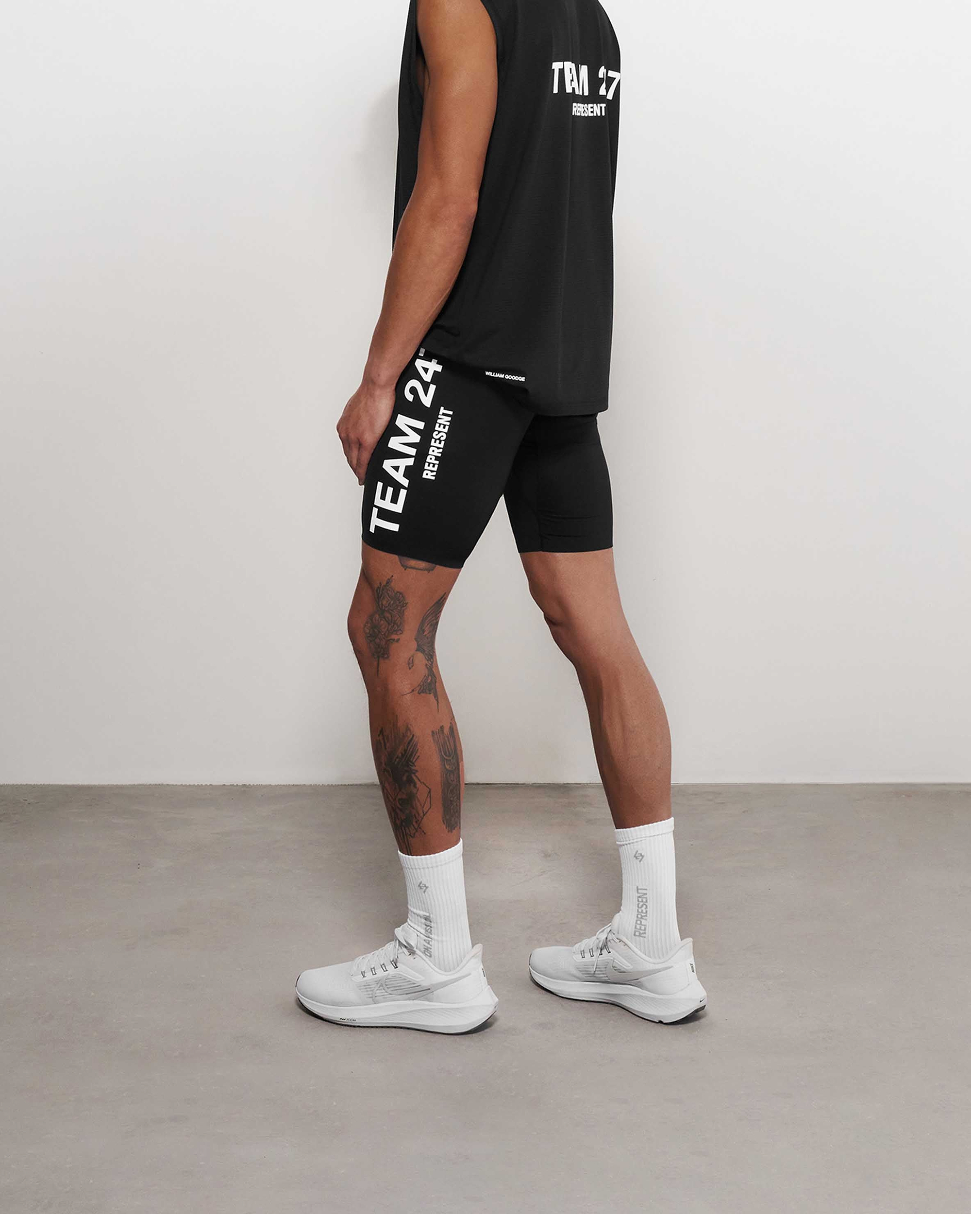 Man wearing black running half tights on a plain white background | Team 247 Half Tight in Black | 4-way stretch performance shorts | 247 Shorts | Represent Clo