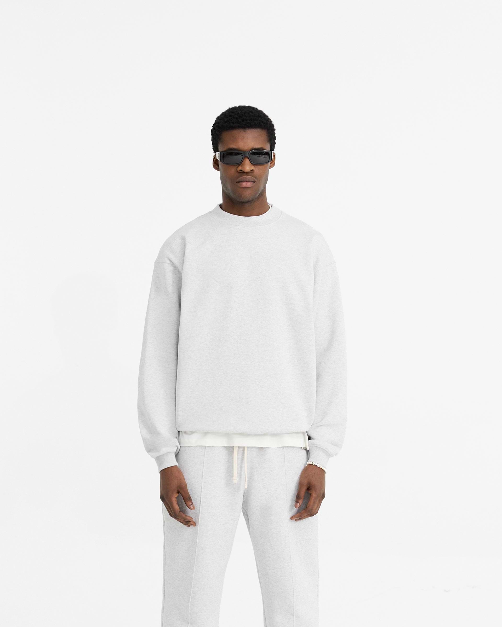 Man wearing a grey oversized sweater on a plain white background | Initial Oversized Sweater in Ice Grey Marl | Oversized sweater in loopback jersey organic cotton | Initial Sweaters | Represent Clo