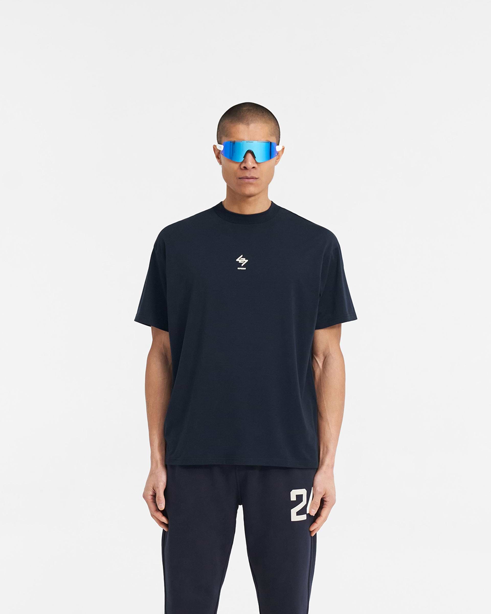 Man wearing a navy oversized t-shirt on a plain white background | 247 Oversized T-Shirt in Navy | Quick dry gym t-shirt with 4-way stretch | 247 T-Shirts | Represent Clo