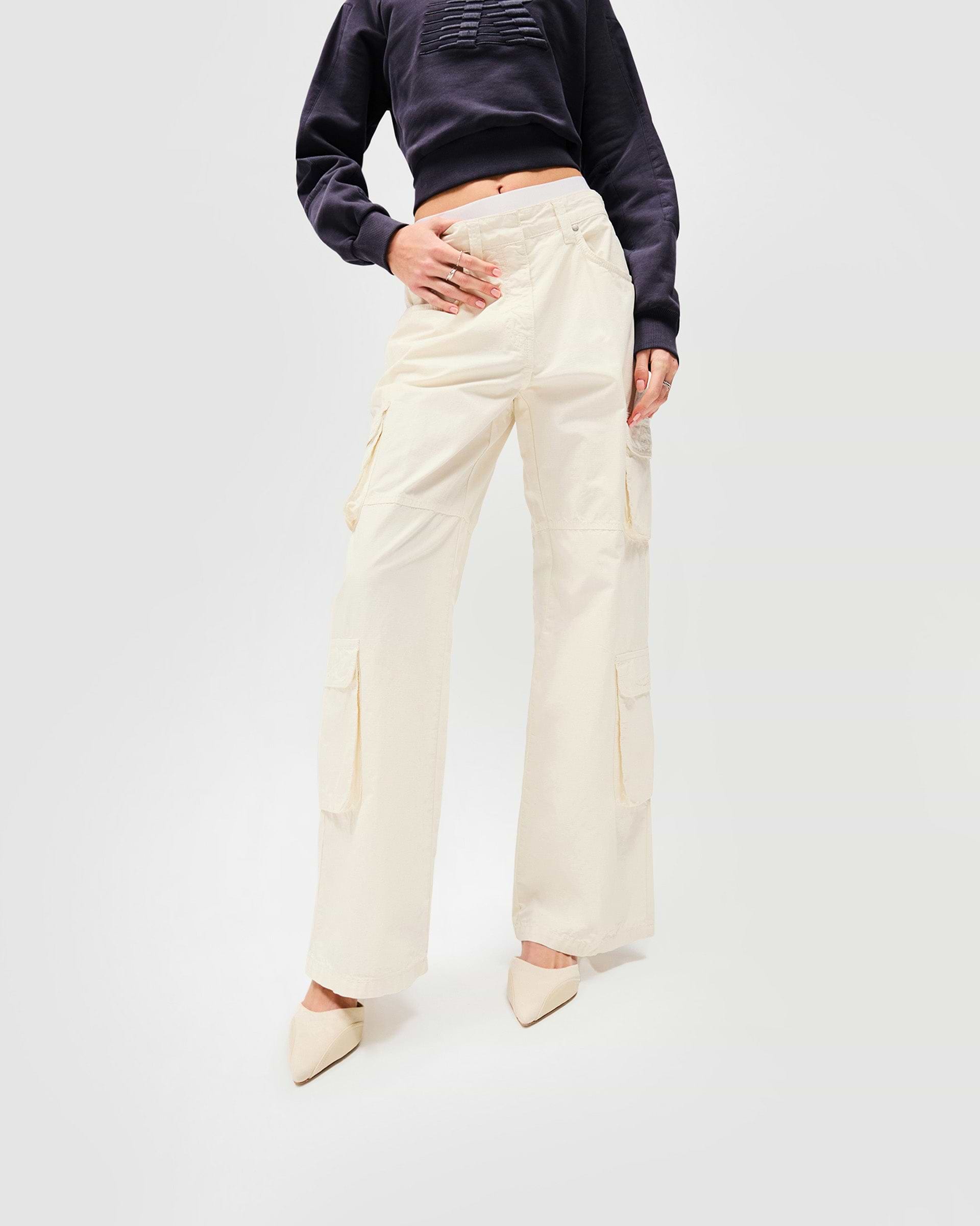Woman wearing antique white cargo pants on a plain white background | Fender Cargo in Antique White | Cargo pants with ripstop cotton and wide legs | Womens SS25 Bottoms | Represent Clo
