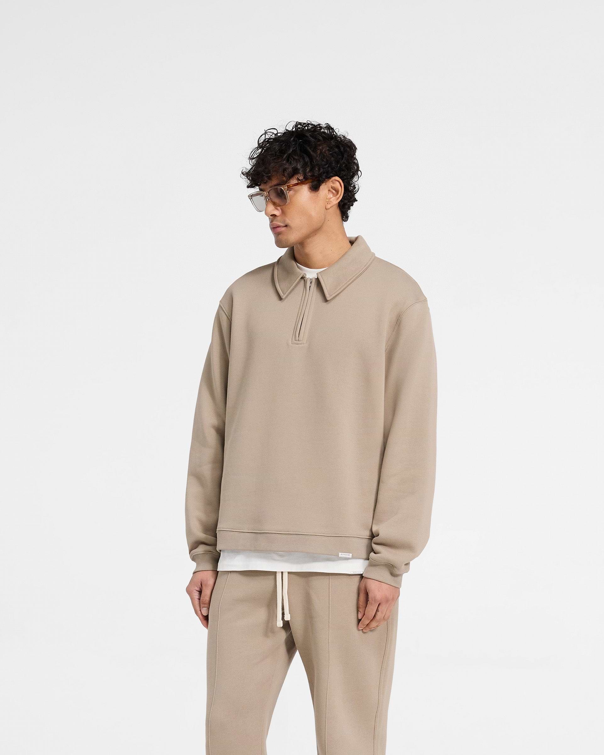 Back product image of a mens beige quarter zip on a plain white background | Initial Boxy Quarter Zip in Dune | Oversized boxy fit sweater with RiRi zip and embroidered details | Initial Sweaters | Represent Clo