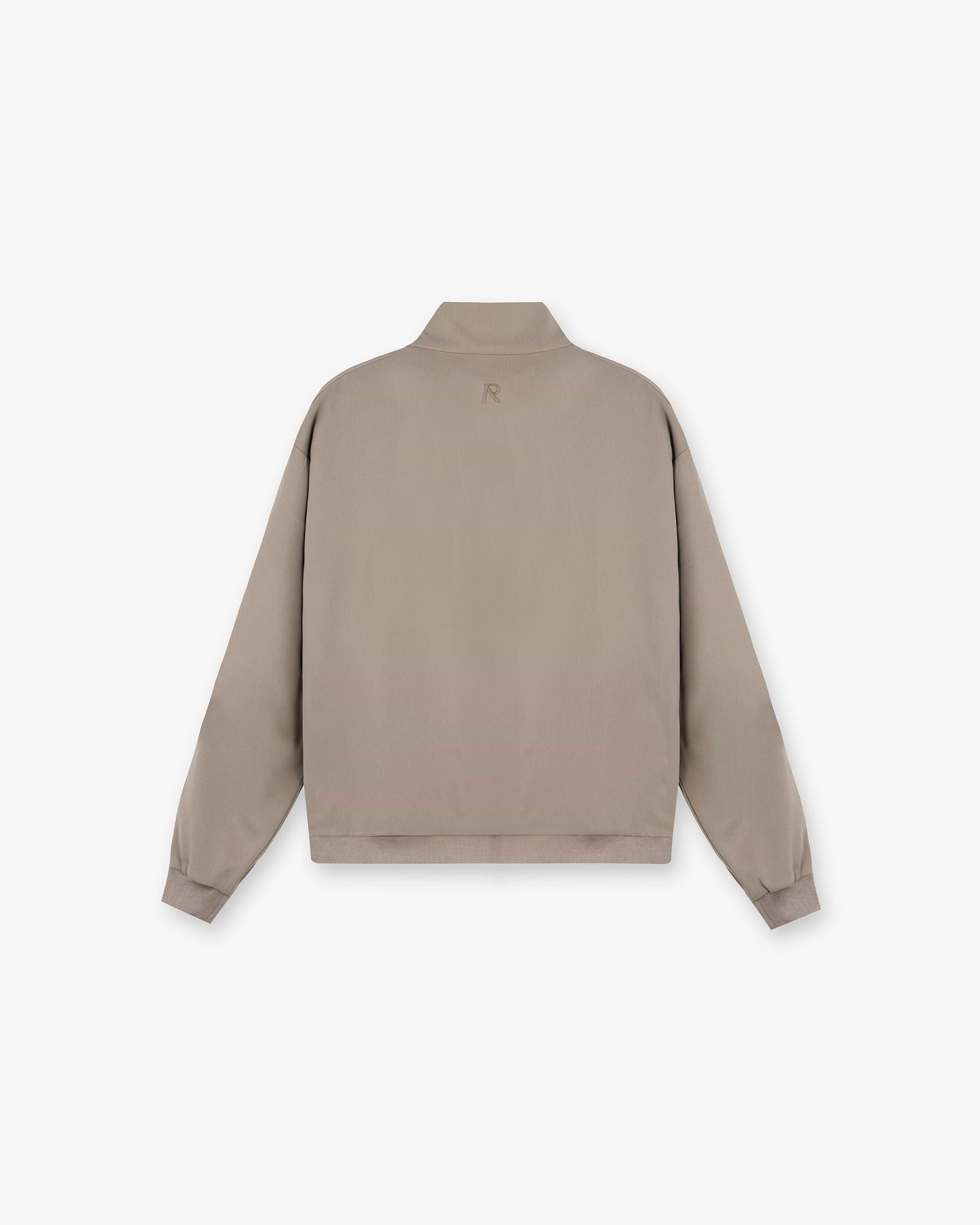 Back product image of a mens beige track jacket on a plain white background | Initial Track Jacket in Dune | Oversized fit track jacket with double-ended zip and welt pockets | Initial Outerwear | Represent Clo