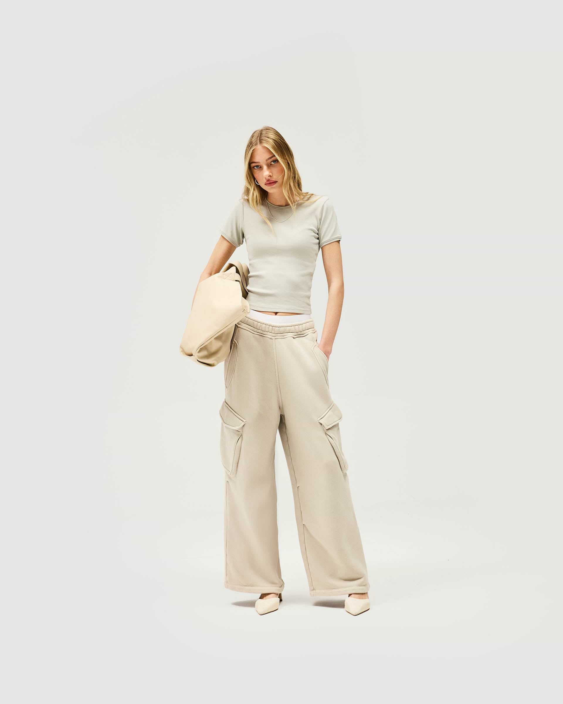 Woman wearing a grey cropped t-shirt on a plain white background | Initial Rib Baby T-Shirt in Storm | Cropped fit ribbed tops with high build embroidery | Womens Initial Tops | Represent Clo