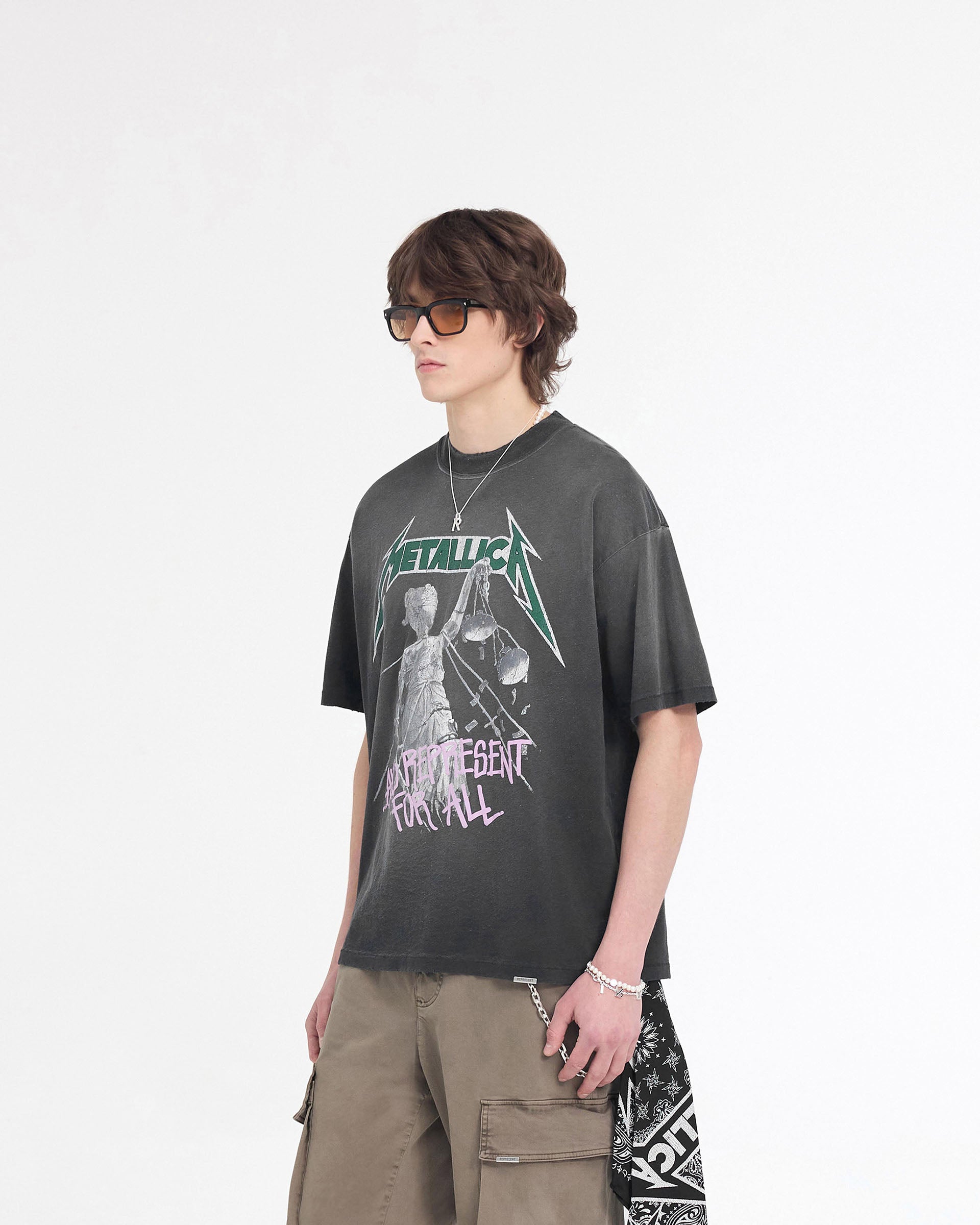 Man wearing a stained black t-shirt on a plain white background | Represent X Metallica Justice T-Shirt in Stained Black | Slightly oversized Metallica t-shirt with screen and puff printed custom graphic | SS24 T-Shirts | Represent Clo