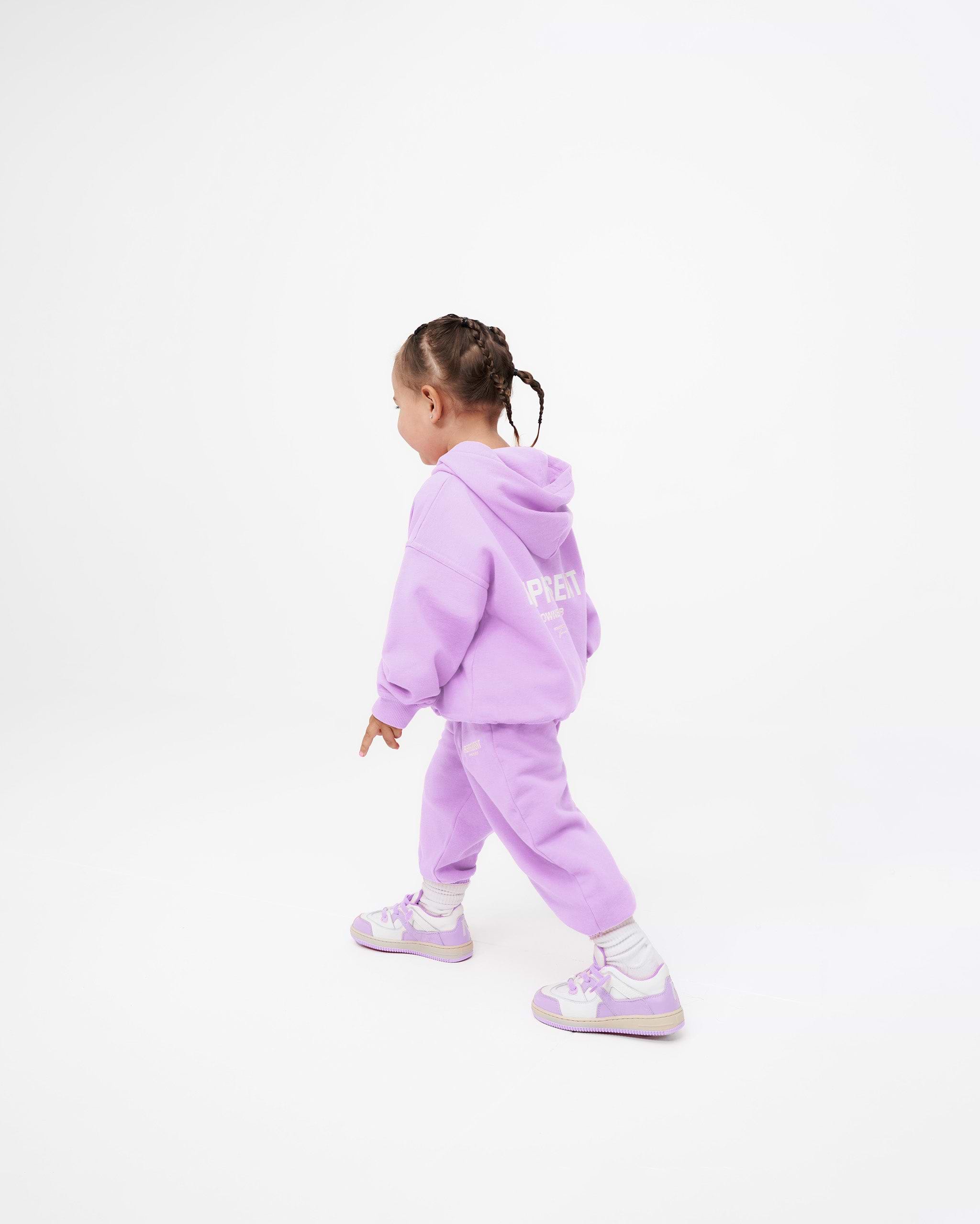 Child wearing lilac sweatpants on a plain white background | Represent Mini Owners Club Sweatpants in Lilac | Kids joggers with elasticated waistband | Owners Club Pants | Represent Clo