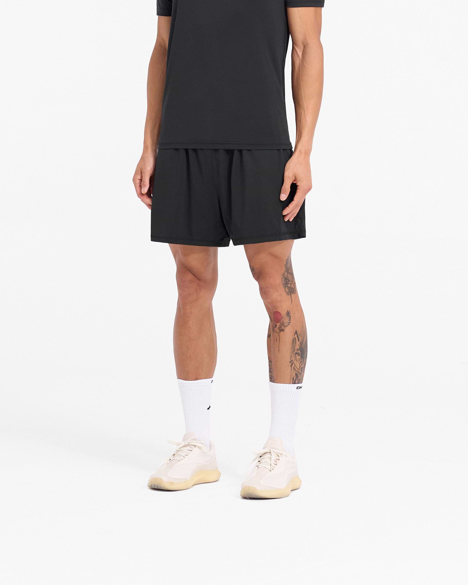 Back product image of mens black mesh shorts on a plain white background | 247 DNA Mesh Shorts in Black | Oversized training shorts with zip pockets and side split hem | 247 Shorts | Represent Clo