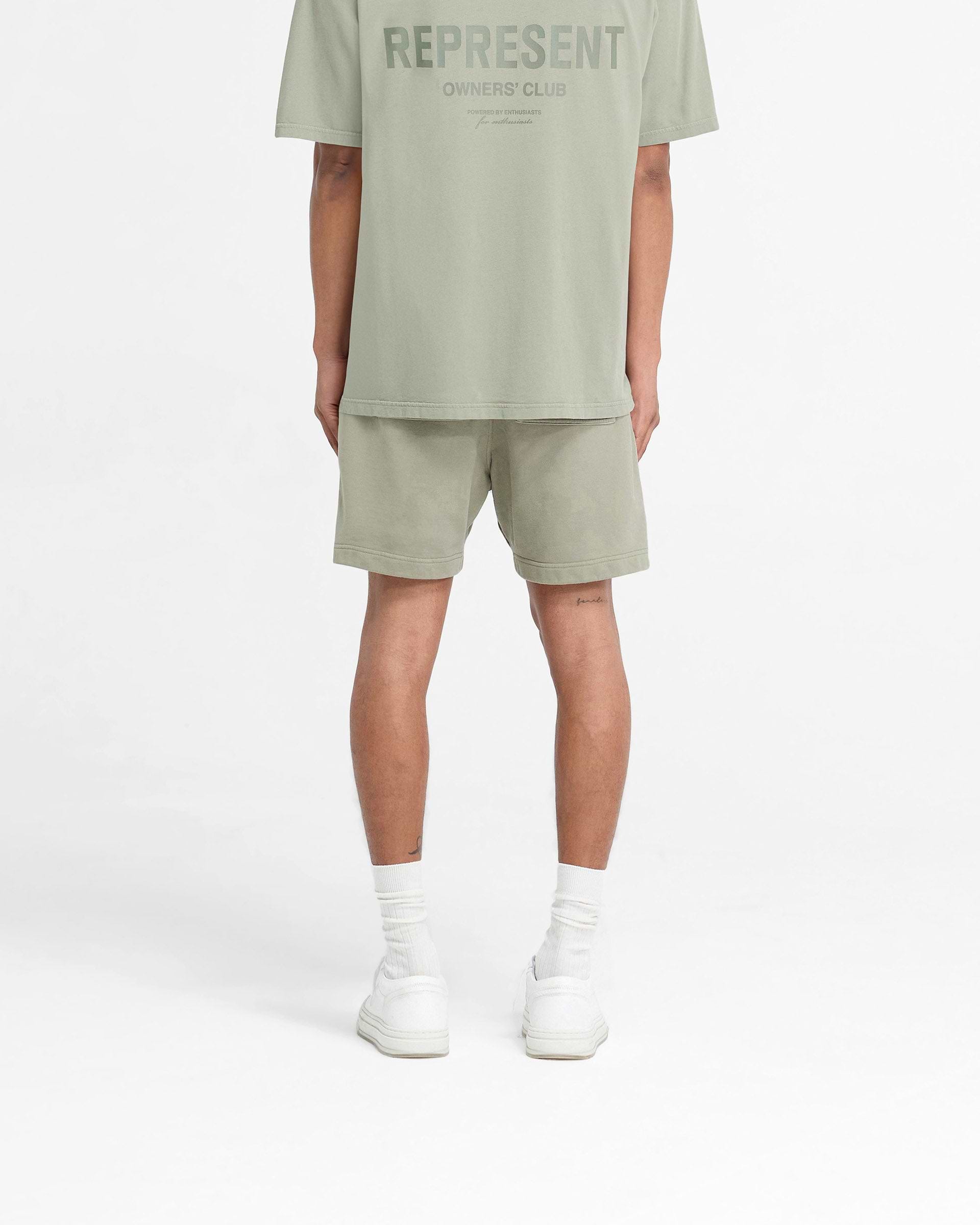 Man wearing pastel green shorts on a plain white background | Represent Owners Club Shorts in Pastel Green | Relaxed fit shorts with elasticated waistband | Owners Club Shorts | Represent Clo