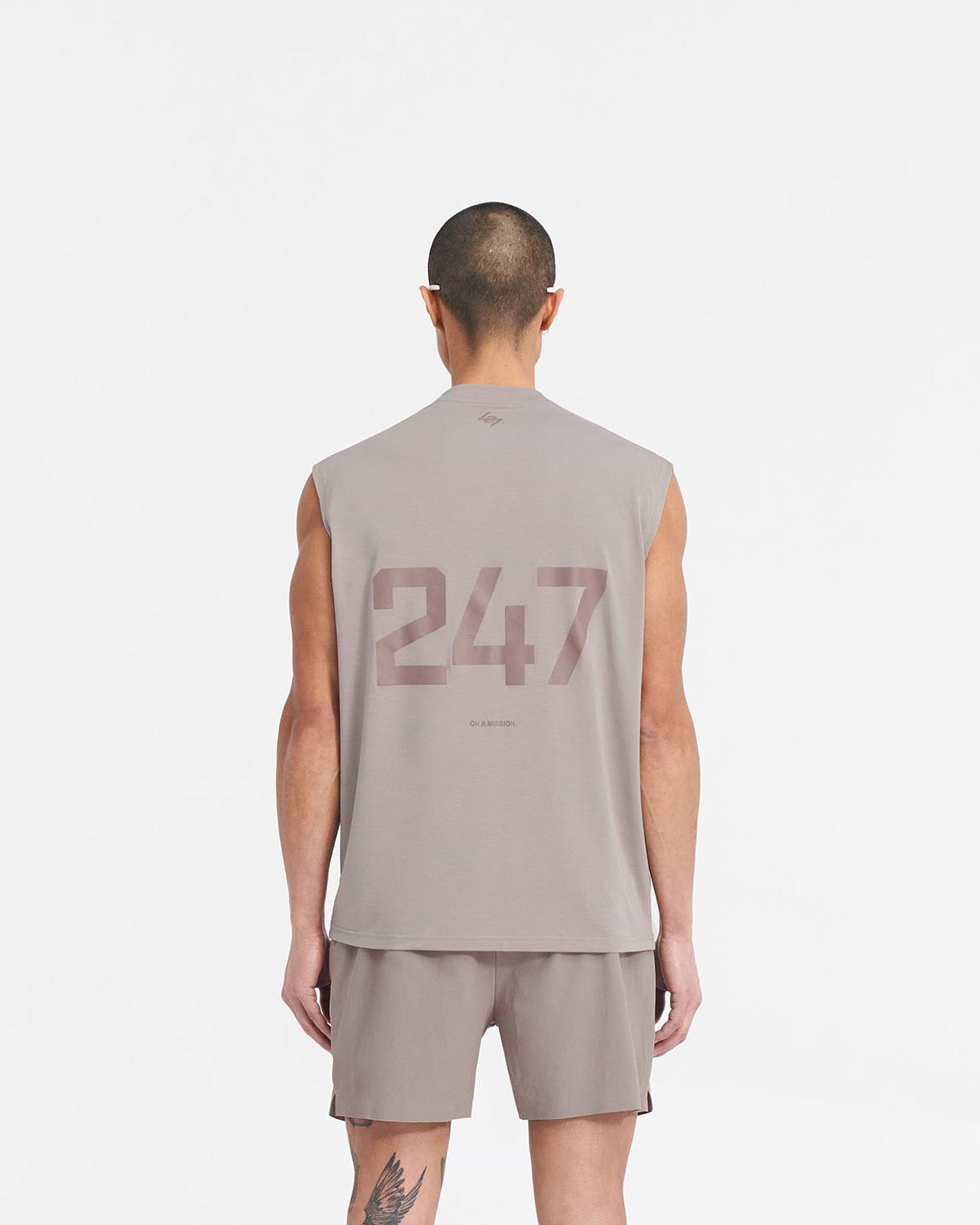 Man wearing an oversized grey tank top on a plain white background | 247 Oversized Tank in Cinder | Lightweight tank with breathable 4-way stretch fabric | 247 T-Shirts | Represent Clo