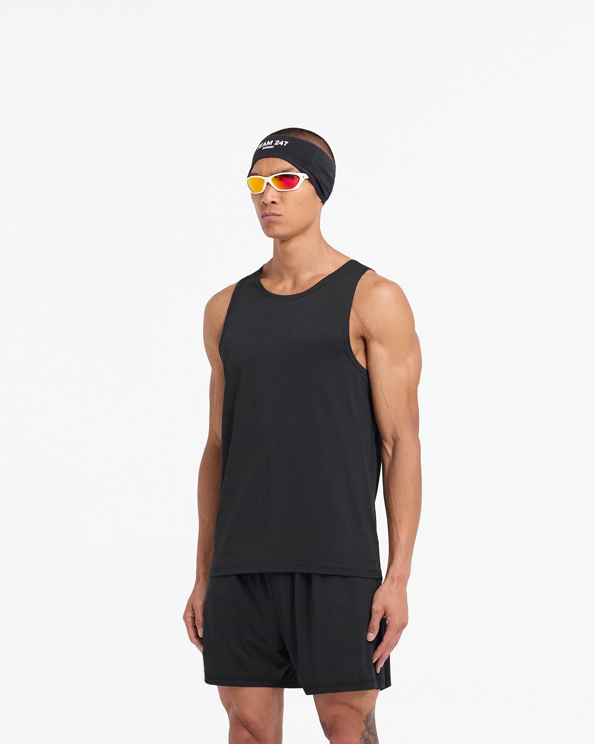 Man wearing a black mesh vest on a plain white background | 247 DNA Mesh Vest in Black | Regular fit training vest with moisture-wicking properties | 247 T-Shirts | Represent Clo