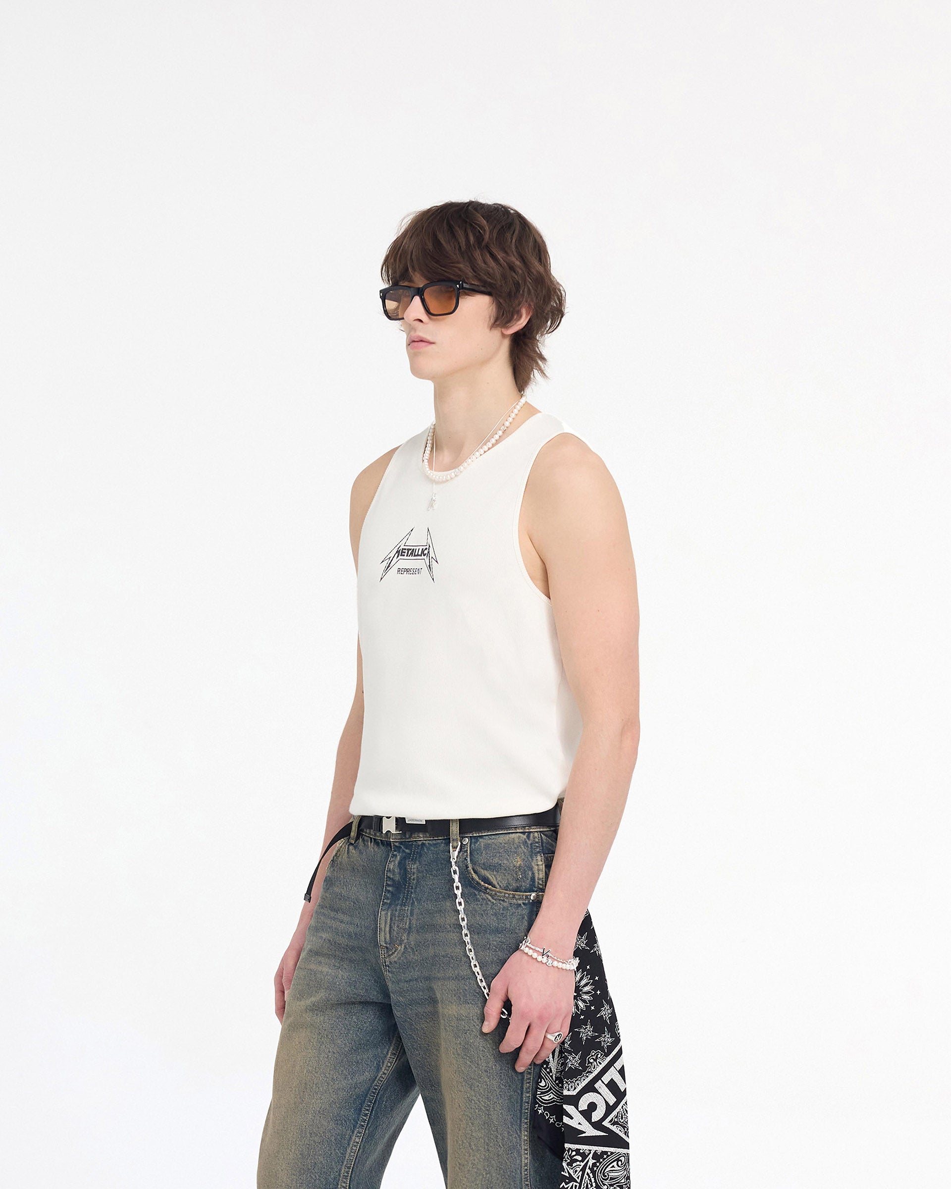 Man wearing a white ribbed vest on a plain white background | Represent X Metallica Local Crew Vest in Flat White | Vest with cracked Metallica logo | SS24 T-Shirts | Represent Clo