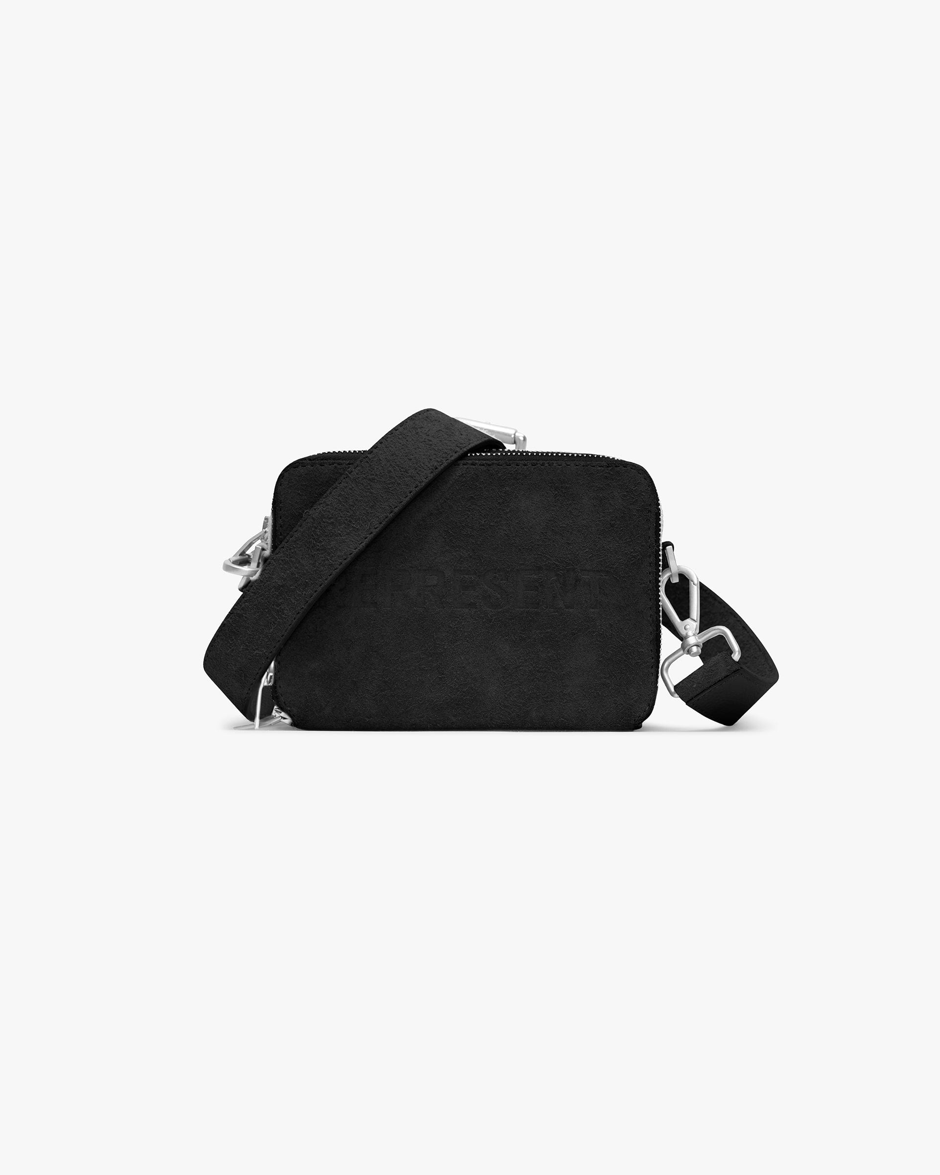 Front product image of a black suede camera bag on a plain white background | Represent Hairy Suede Camera Bag in Black | Suede camera bag with adjustable strap | SS24 Accessories | Represent Clo