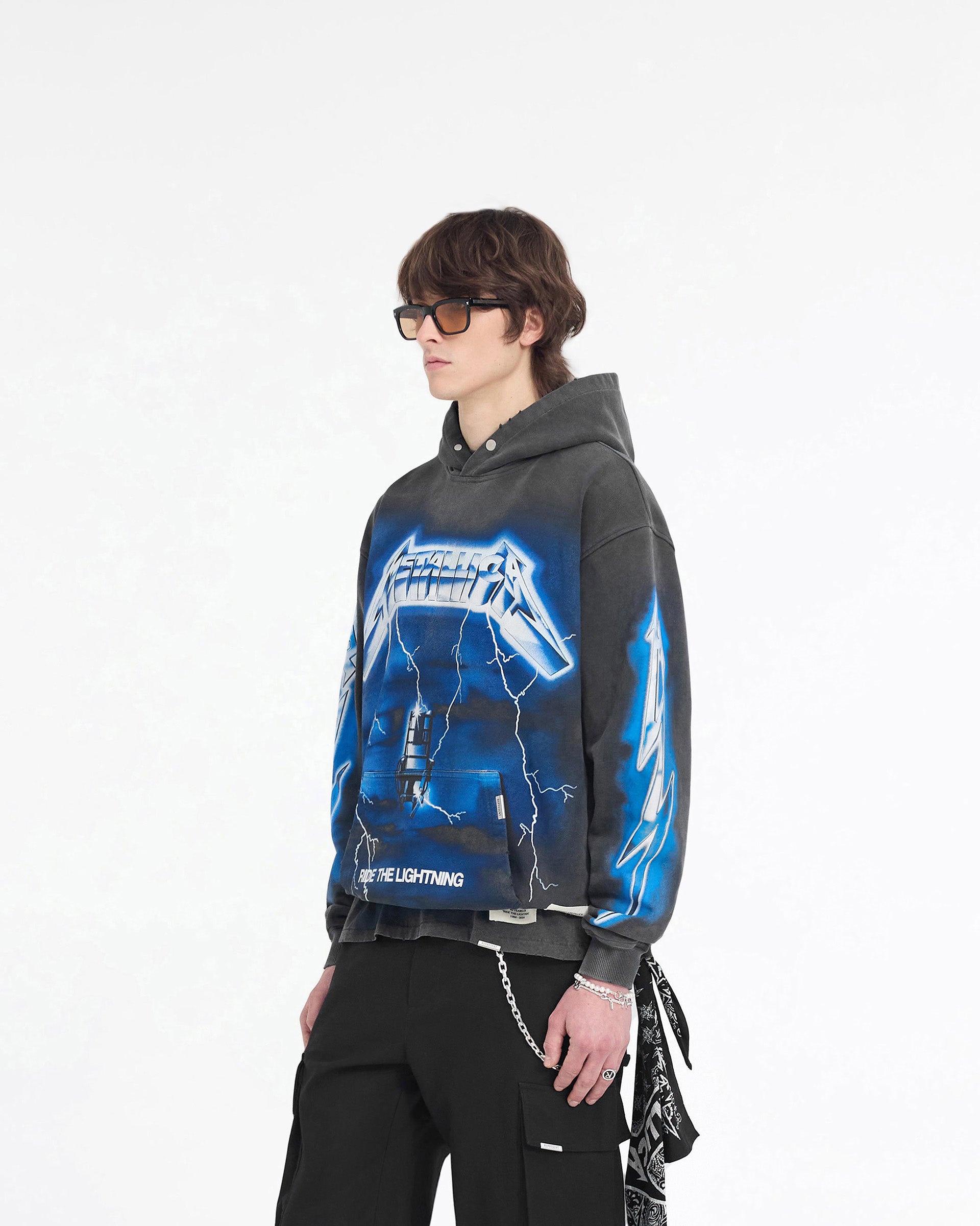 Man wearing a grey hoodie with graphic prints on a plain white background | Represent X Metallica Ride The Lightning Hoodie in Vintage Grey | Hoodie with full front and back jumbo print application | SS24 Hoodies | Represent Clo