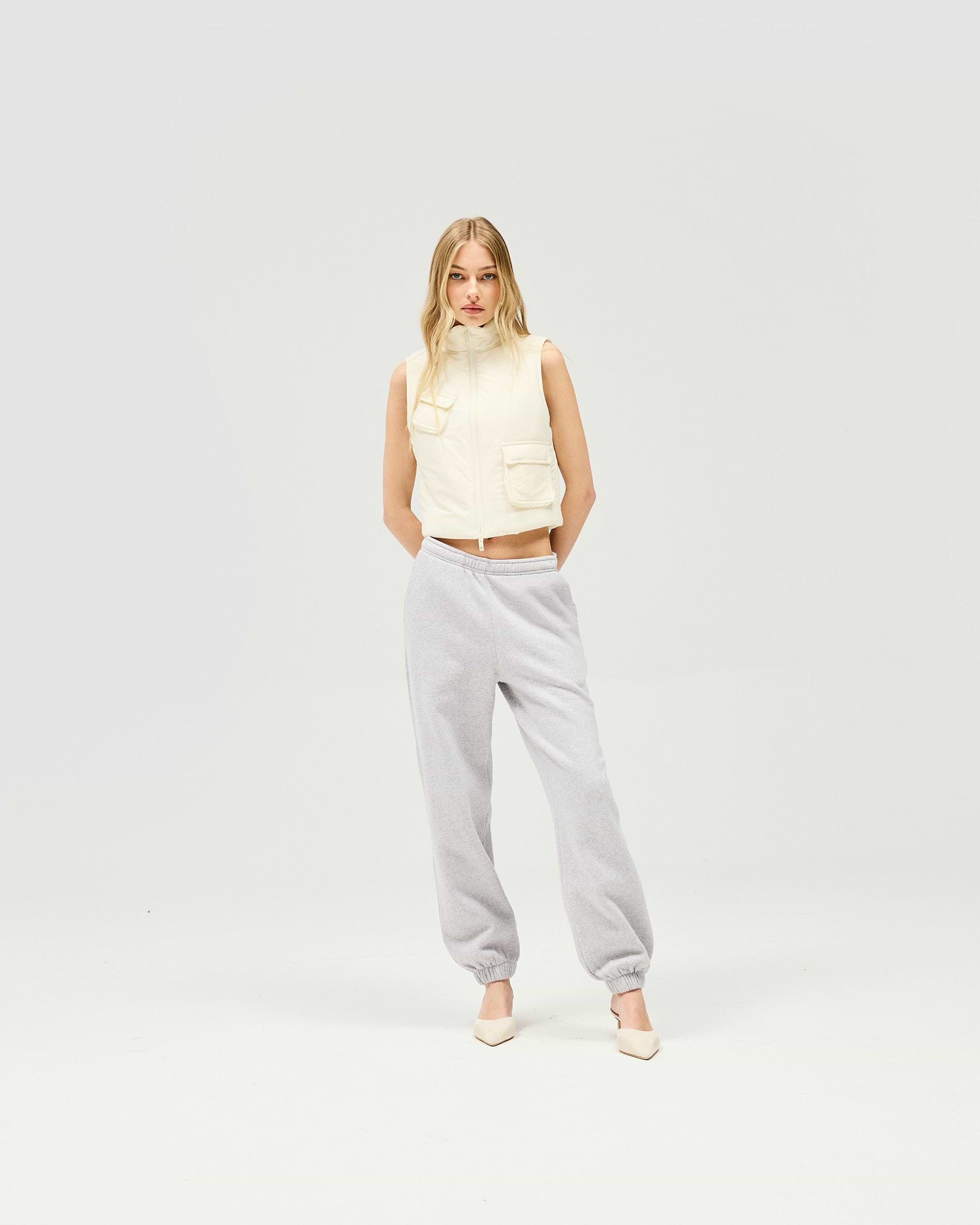 Woman wearing a warm white gilet on a plain white background | Revolver Gilet in Warm White | Shrunken fit gilet with recycled down and double front zip closure | Womens SS25 Outerwear | Represent Clo