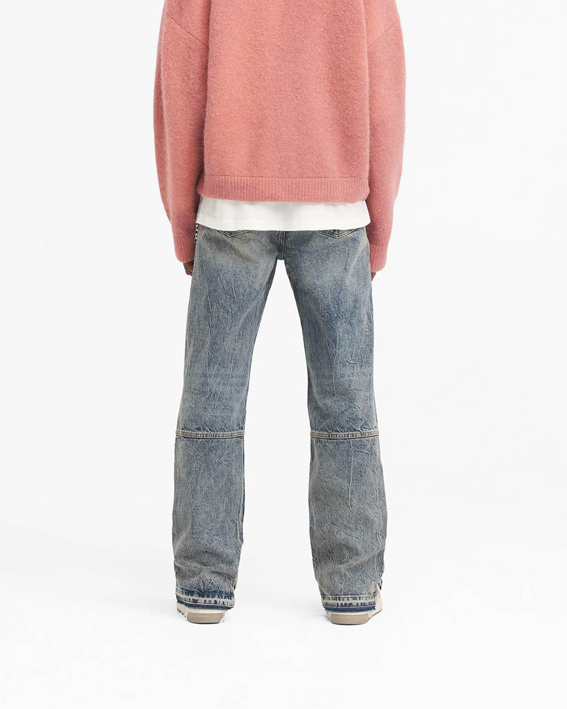 Man wearing mid blue denim jeans on a plain white background | R2 Stepped Hem Denim in Mid Blue | Straight leg jeans with stepped hem and whiskering | SS24 Denim | Represent Clo