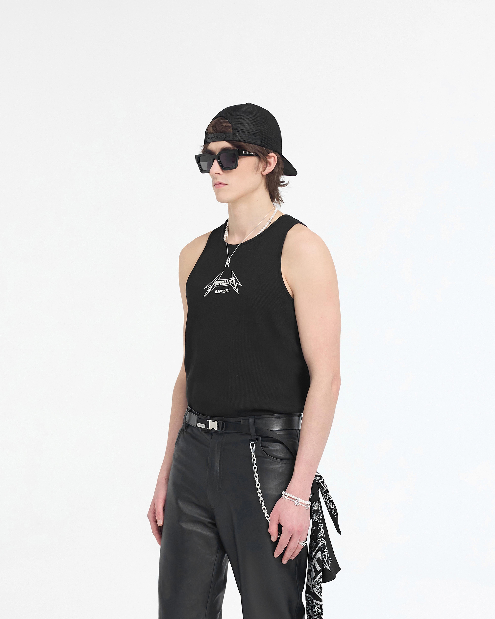 Man wearing a black ribbed vest with Metallica logo on a plain white background | Represent X Metallica Local Crew Vest in Jet Black | Regular fit ribbed vest with cracked Metallica logo | SS24 T-Shirts | Represent Clo