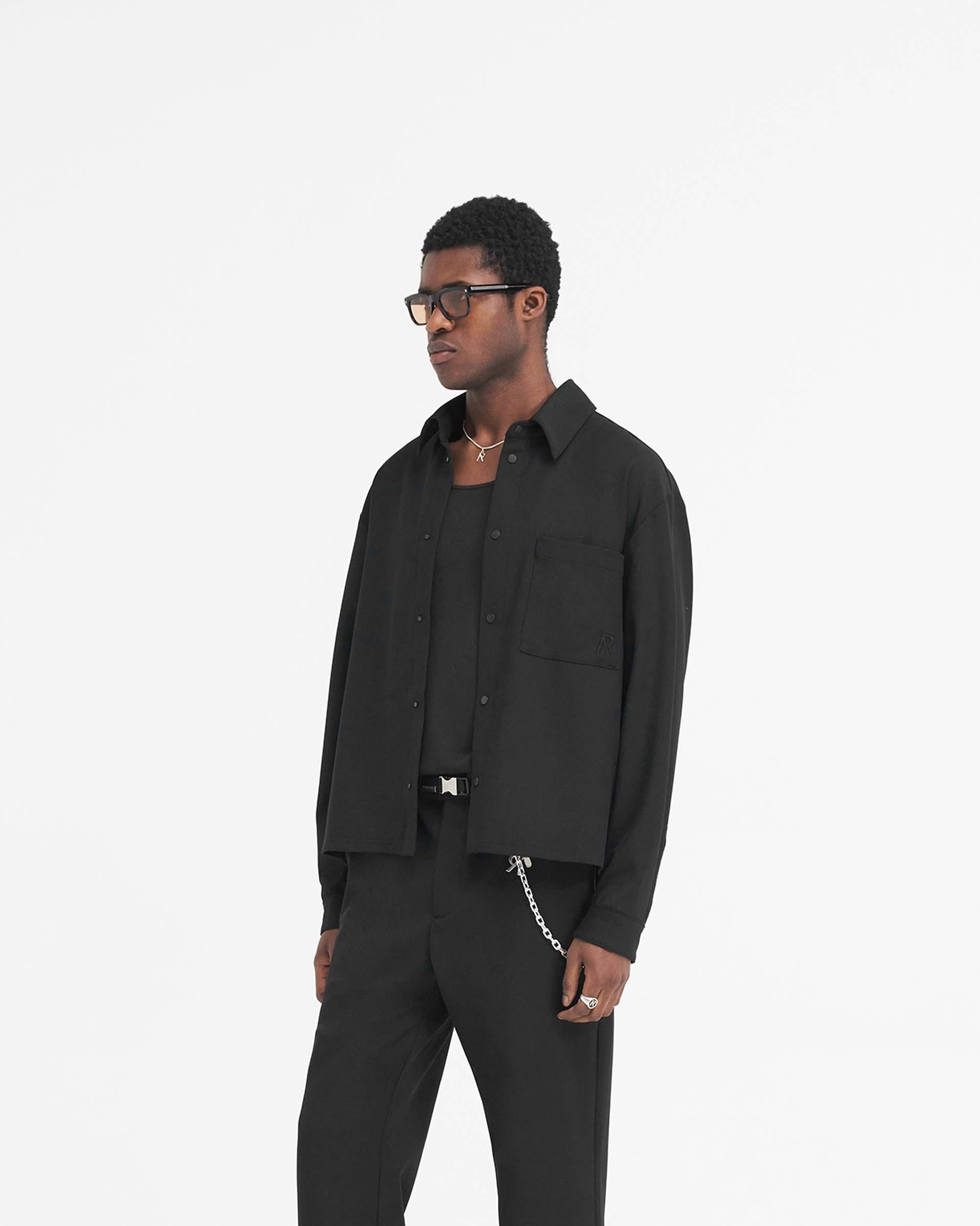 Back product image of a mens black dress shirt on a plain white background | Initial Cropped Dress Shirt in Black | Wool blend shirt with high build logo and V yoke | SS24 Shirts | Represent Clo