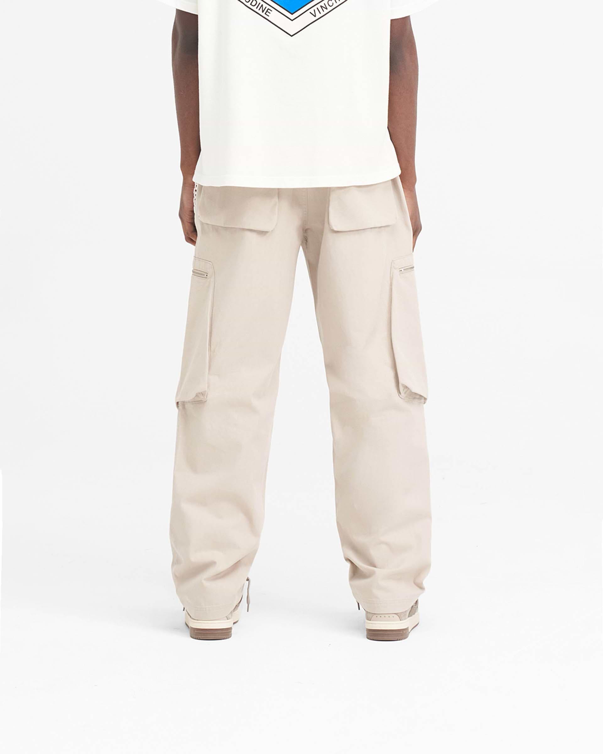 Man wearing cashmere pants on a plain white background | Workshop Pant in Cashmere | Luxury herringbone cotton pants with asymmetric angled pockets | SS24 Pants | Represent Clo