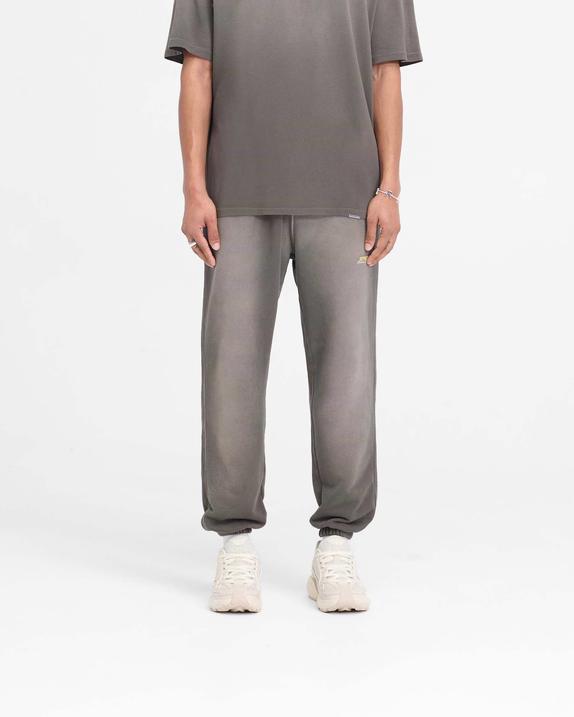 Man wearing washed olive sweatpants on a plain white background | Patron Of The Club Sweatpant in Washed Olive | Heavy weight cotton sweatpants with elasticated waistband | Patrons Pants | Represent Clo
