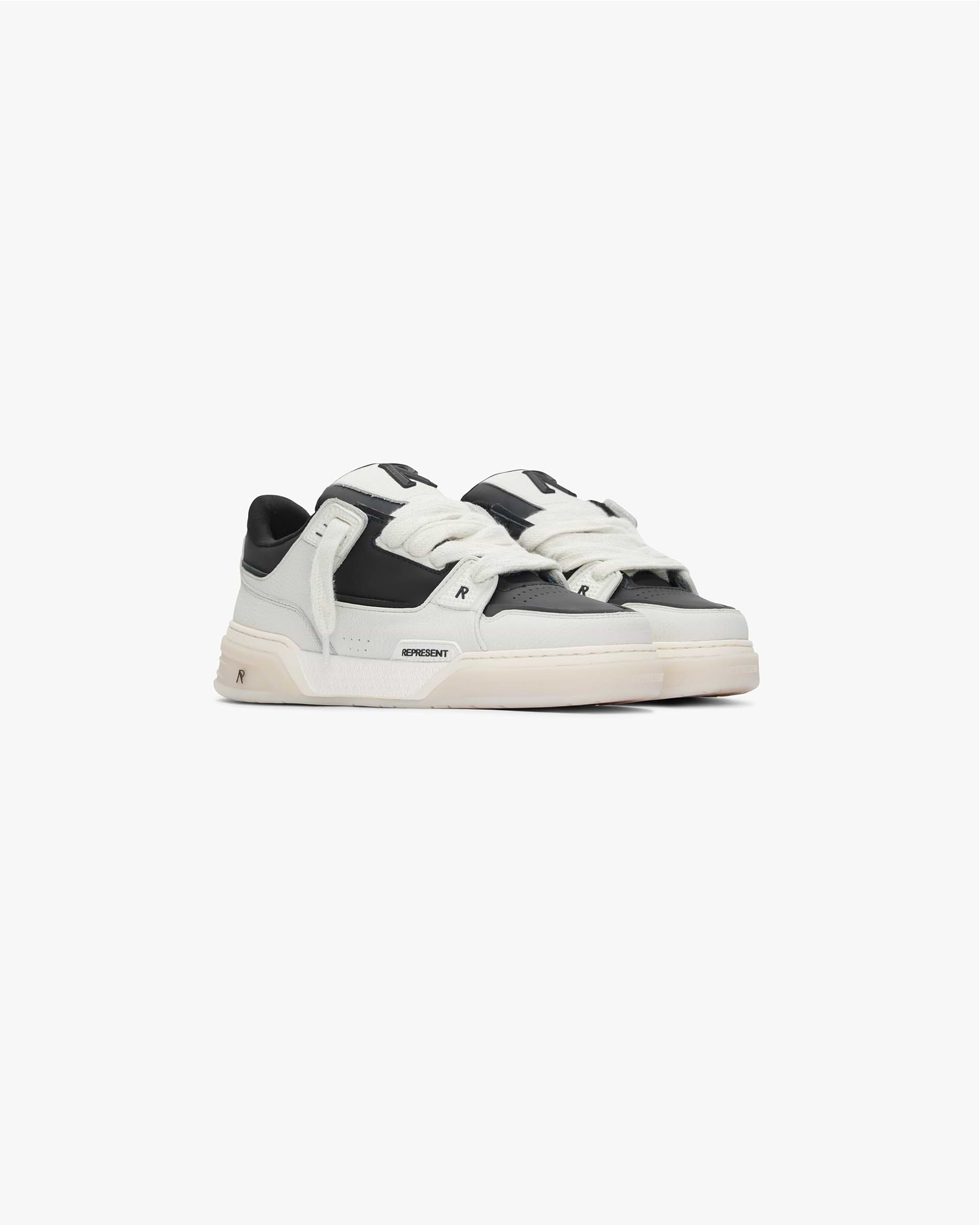 Back product image of a mens white and black sneaker on a plain white background | Studio Sneaker in Vintage White Black | Leather sneaker with TPU trims and tri-color cupsole | SS24 Footwear | Represent Clo