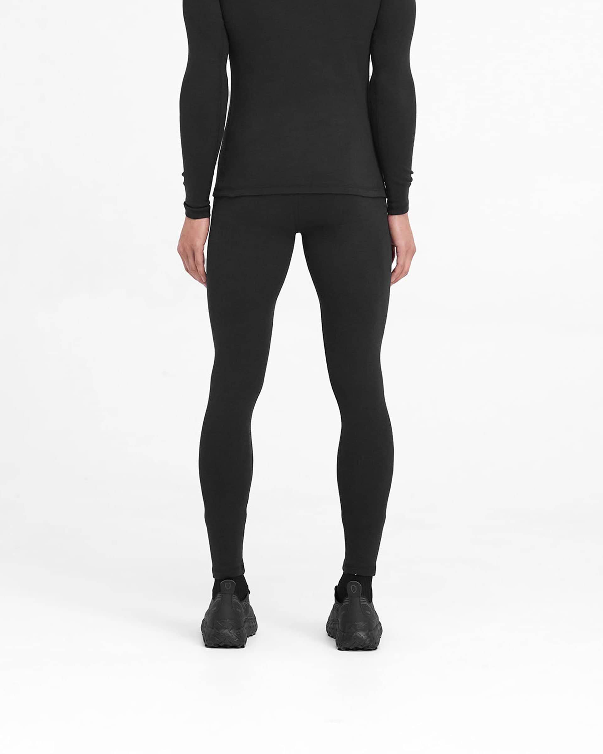 Man wearing ribbed black leggings on a plain white background | 247 Ribbed Legging in Black | Close fit ribbed leggings with 247 logo | 247 Pants | Represent Clo