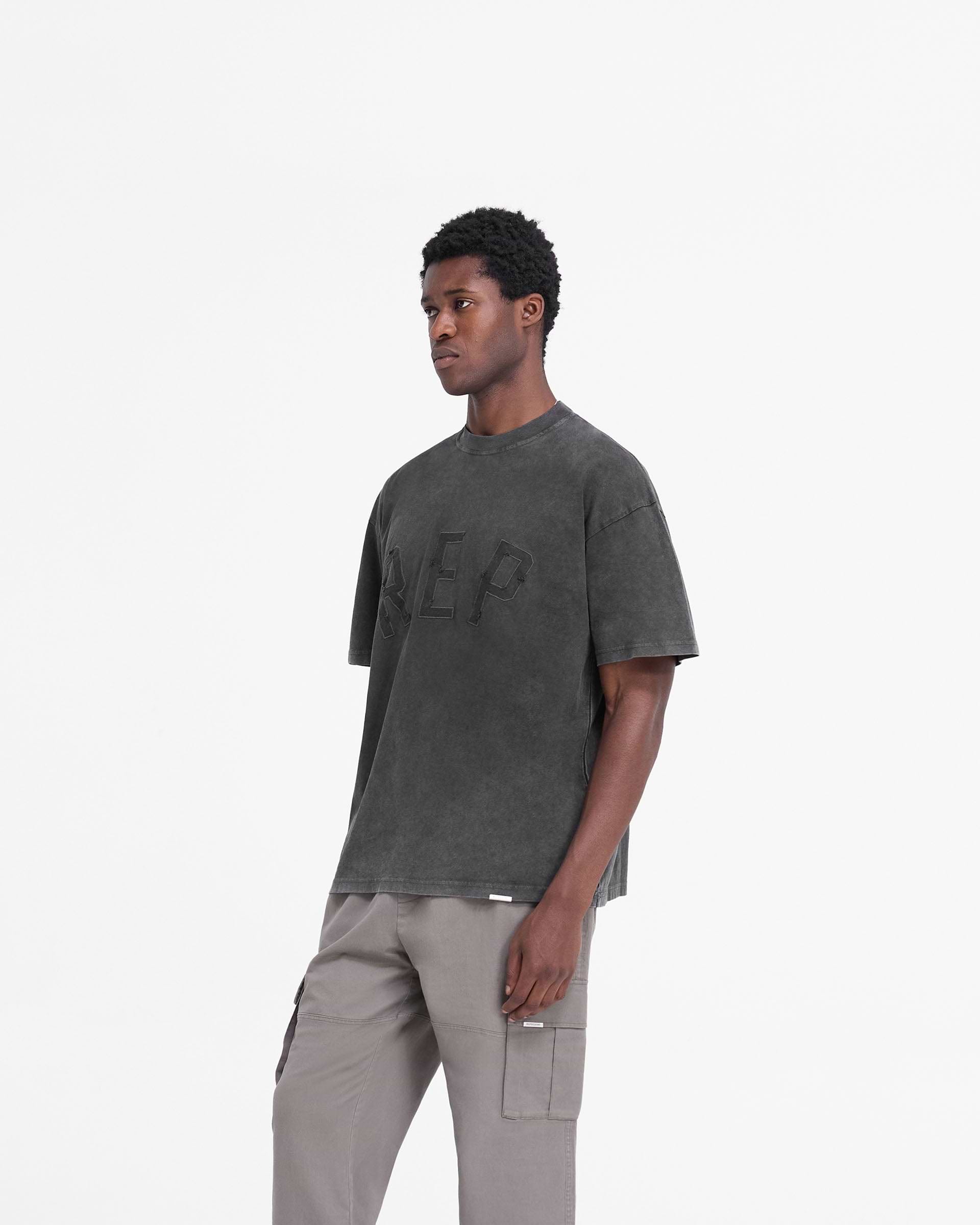 Back product image of a mens black t-shirt on a plain white background | Rep Applique T-Shirt in Vintage Black | Oversized t-shirt with distressed applique logo | FW24 T-Shirts | Represent Clo