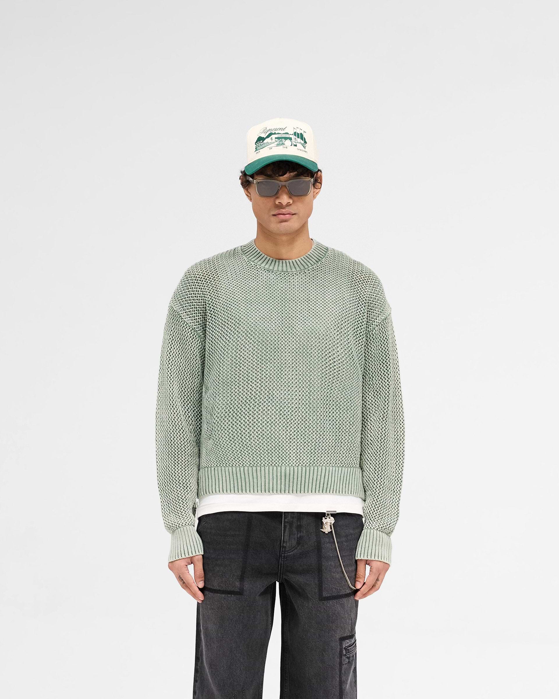 Man wearing a green knit sweater on a plain white background | Open Gauge Knit Sweater in Forest Green | Slightly oversized fit open knit sweater | SS25 Knitwear | Represent Clo