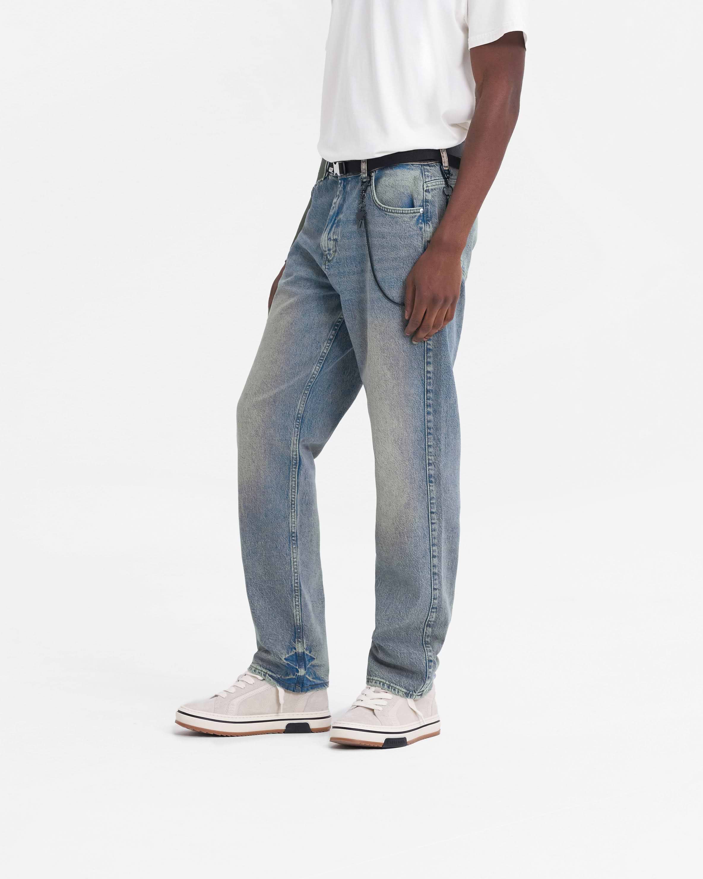 Man wearing blue jeans on a plain white background | R2 Straight Leg Denim in Blue Cream | Straight leg jeans with soft hand feel | FW23 Denim | Represent Clo