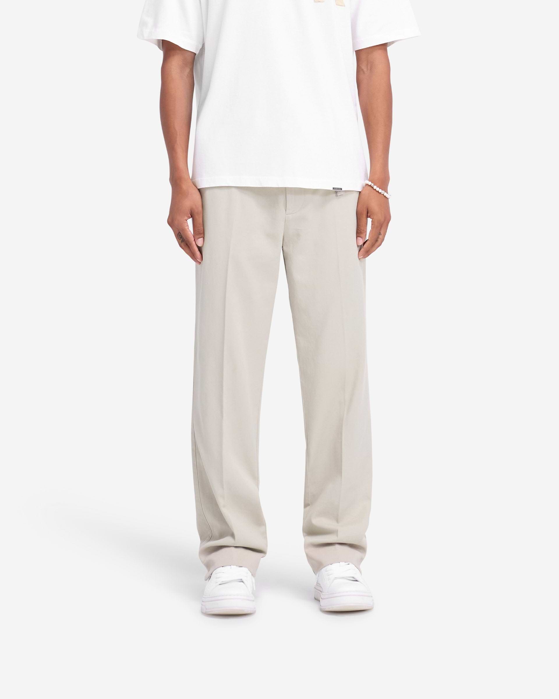 Man wearing stone cotton pants on a plain white background | Cotton Pant in Stone | Straight leg cotton pants with twin needle rise and pockets | FW24 Pants | Represent Clo
