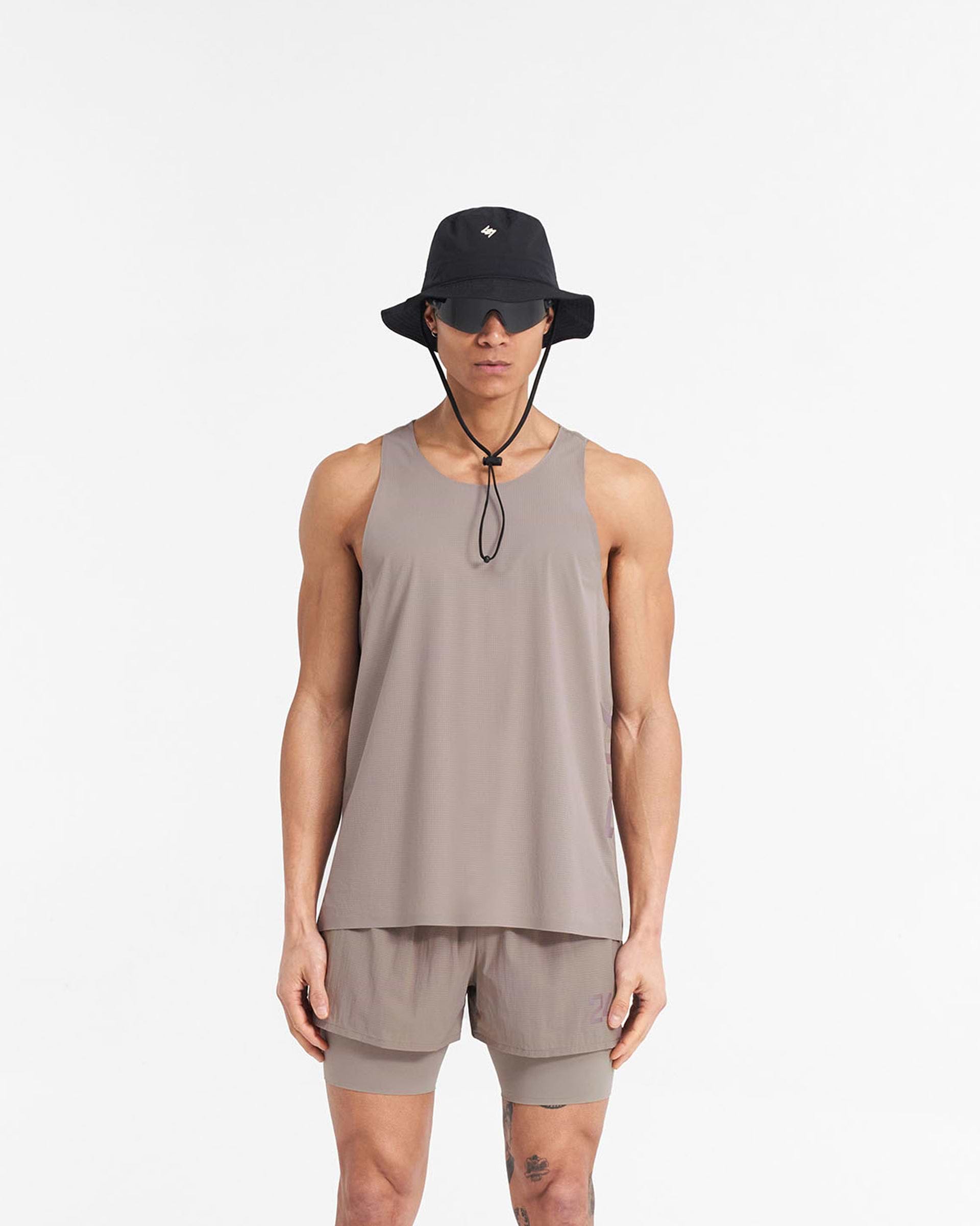 Man wearing a grey training vest on a plain white background | 247 Singlet in Cinder | Perforated singlet with bonded hems | 247 T-Shirts | Represent Clo