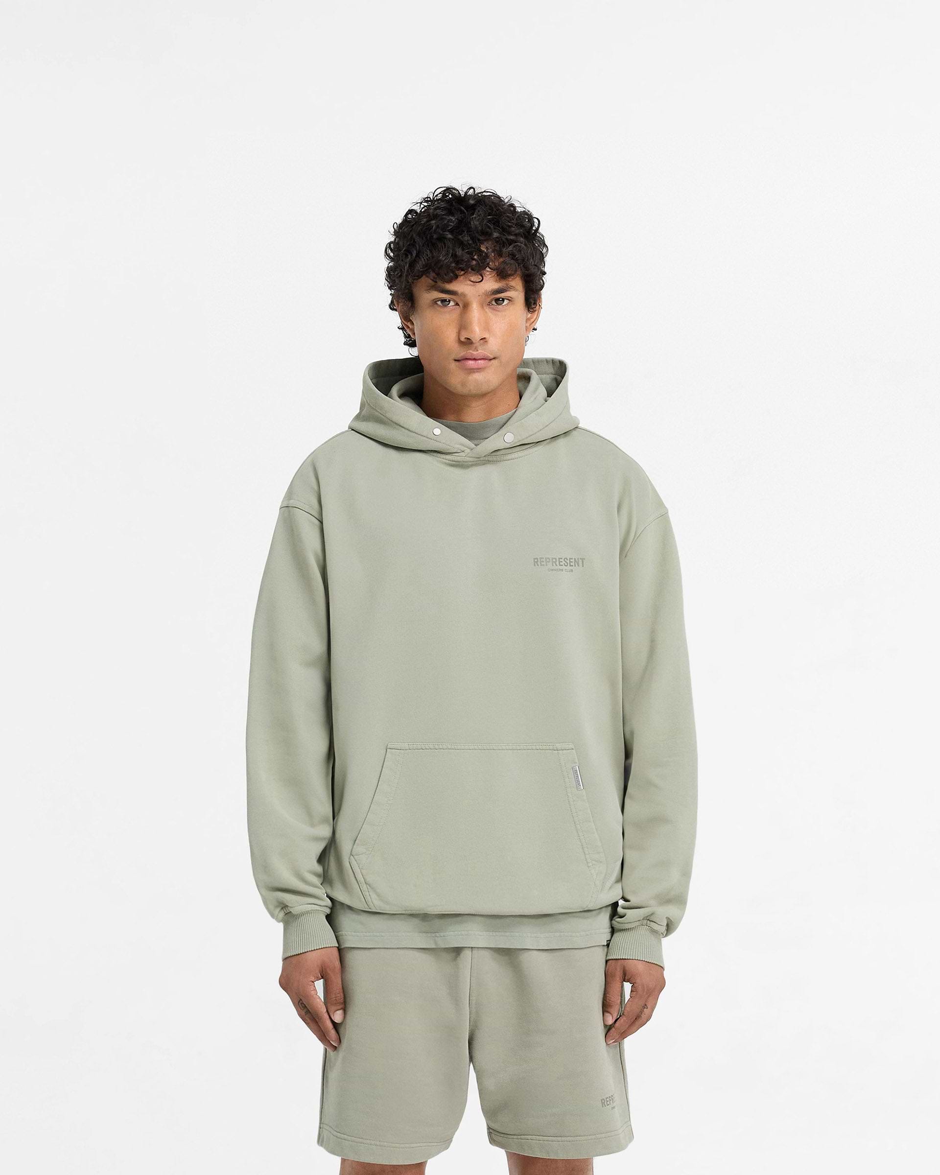 Man wearing an oversized pastel green hoodie on a plain white background | Represent Owners Club Hoodie in Pastel Green | Oversized loopback jersey hoodie with ribbed trims | Owners Club Hoodies | Represent Clo