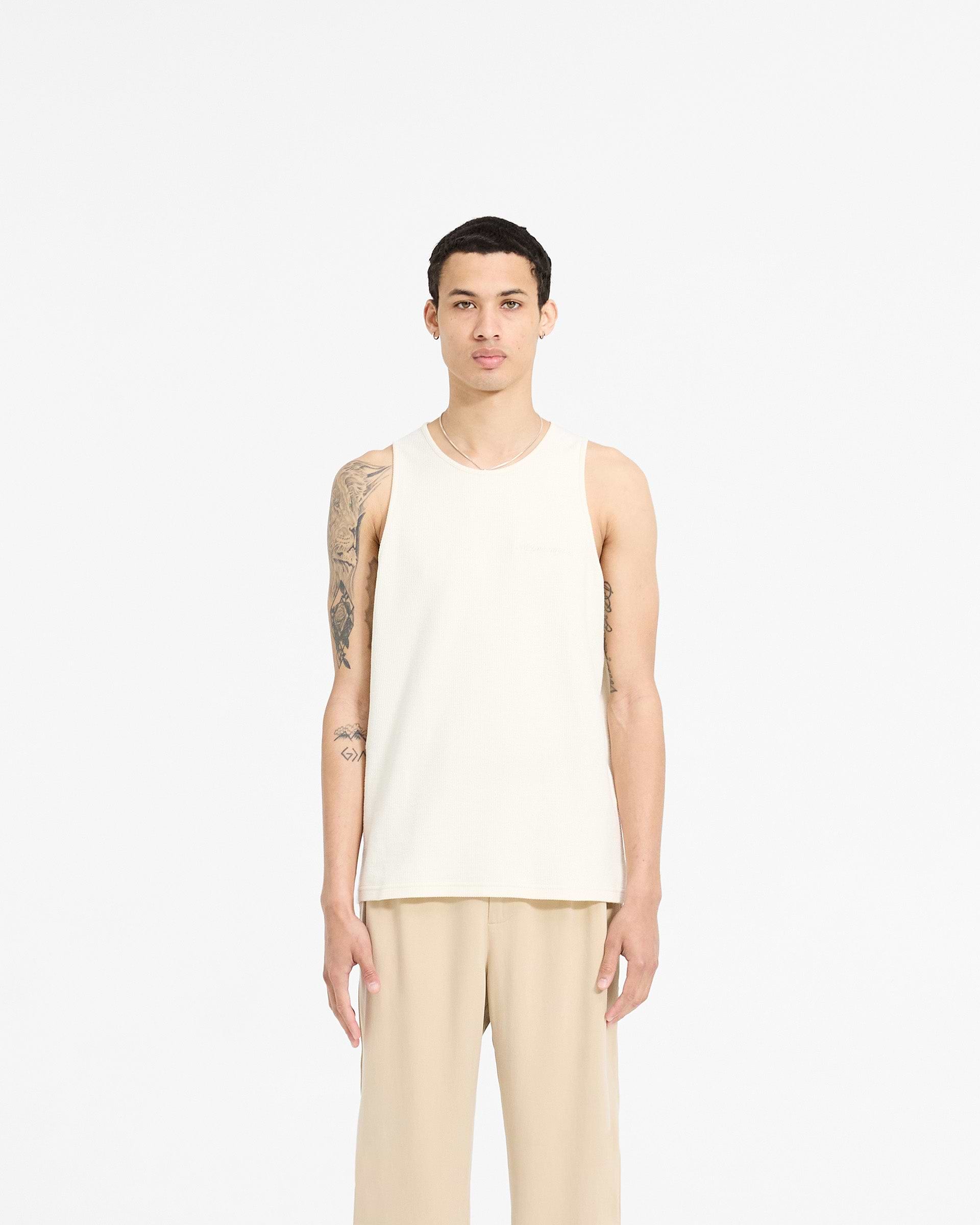 Man wearing an antique white vest on a plain white background | Waffle Vest in Antique White | Regular fit waffle jersey vest with embroidery | SC24 T-Shirts | Represent Clo