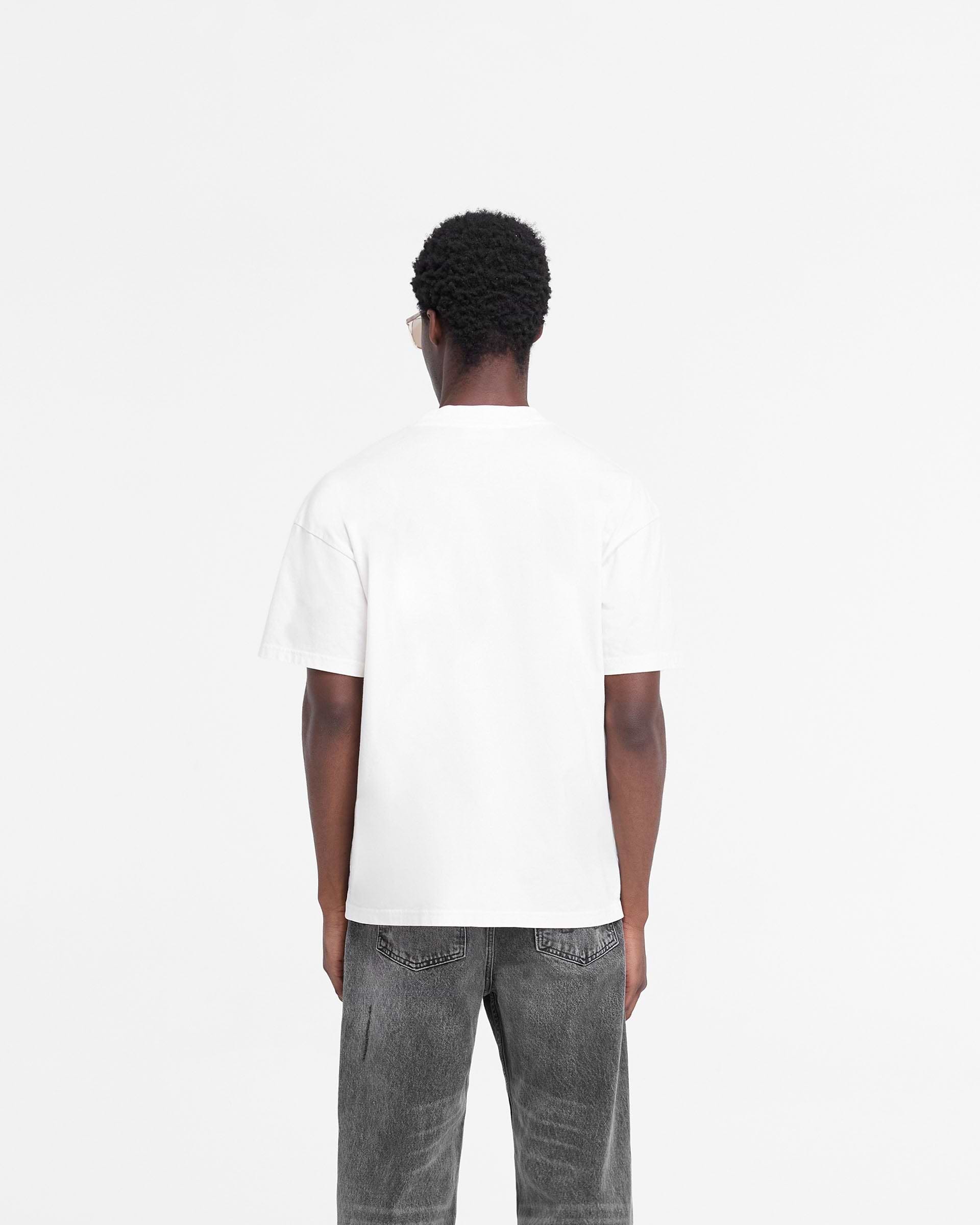 Man wearing an oversized white t-shirt on a plain white background | Rep Applique T-Shirt in Flat White | T-shirt with distressed applique logo | FW24 T-Shirts | Represent Clo
