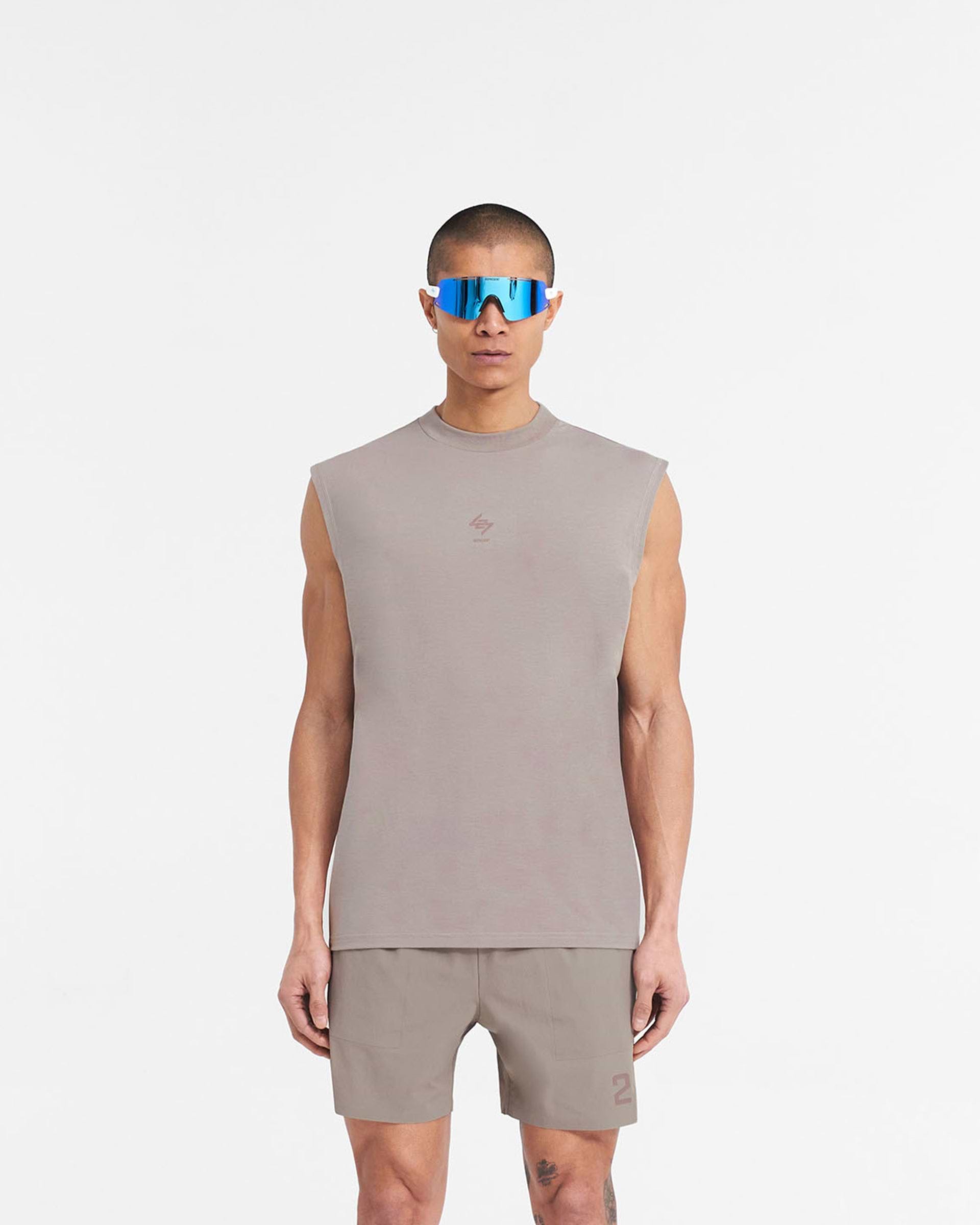 Man wearing a grey oversized tank top on a plain white background | 247 Oversized Tank in Cinder | Lightweight tank top with breathable fabric and 4-way stretch | 247 T-Shirts | Represent Clo