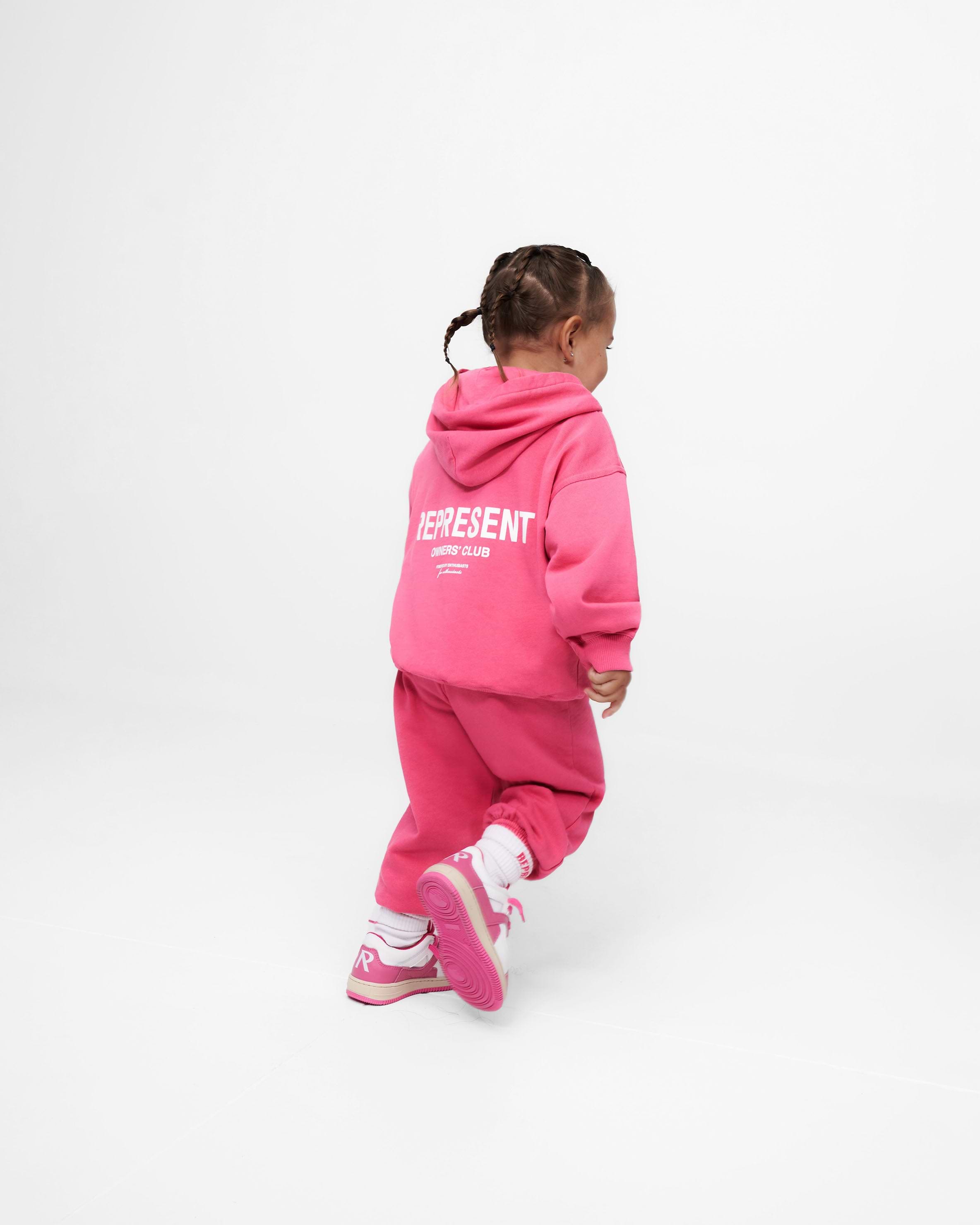 Child wearing pink sweatpants on a plain white background | Represent Mini Owners Club Sweatpants in Bubblegum Pink | Kids sweatpants with elasticated waistband | Owners Club Pants | Represent Clo