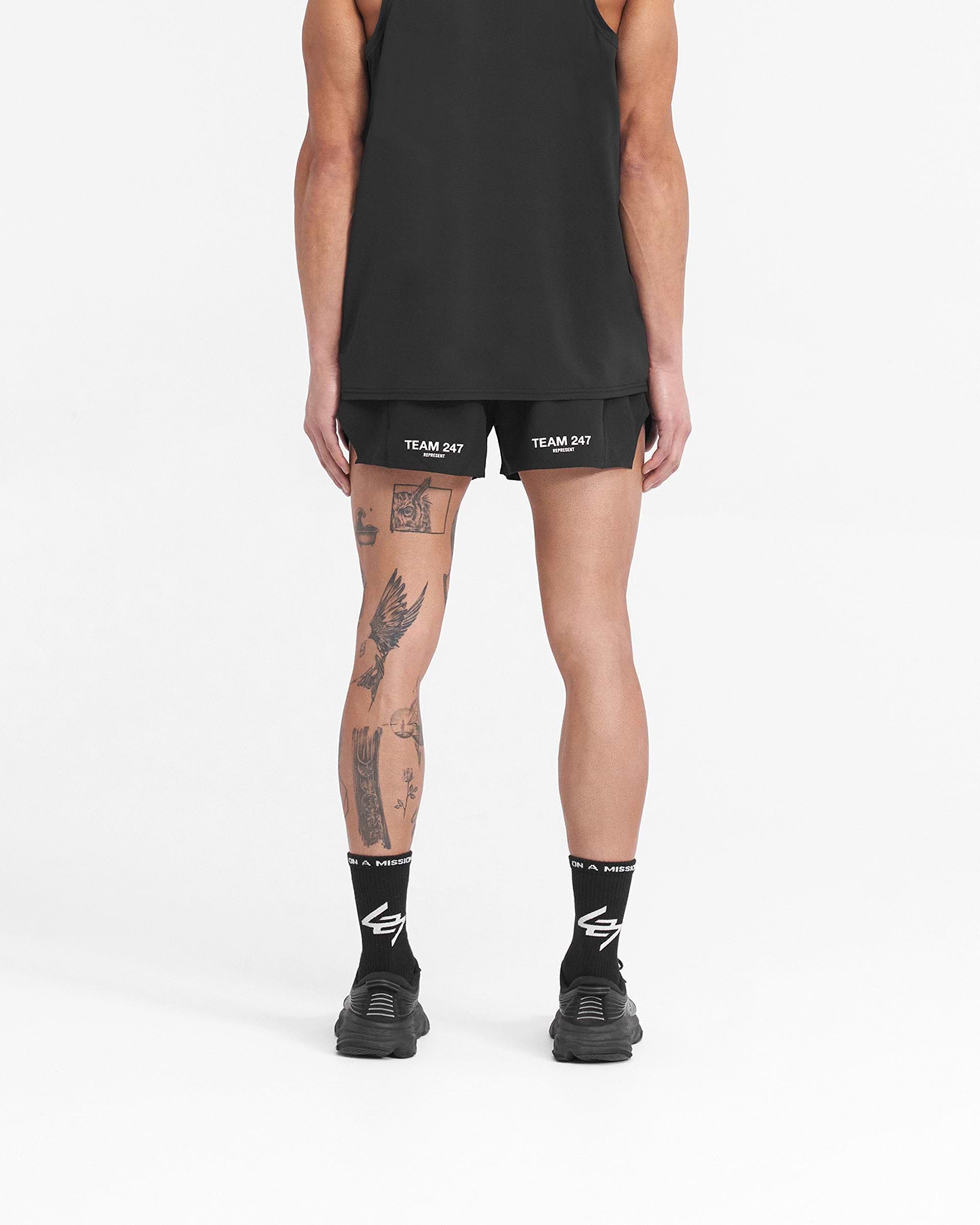 Man wearing black race shorts on a plain white background | Team 247 Race Shorts in Jet Black | Shorts with large side split and zip pocket | 247 Shorts | Represent Clo