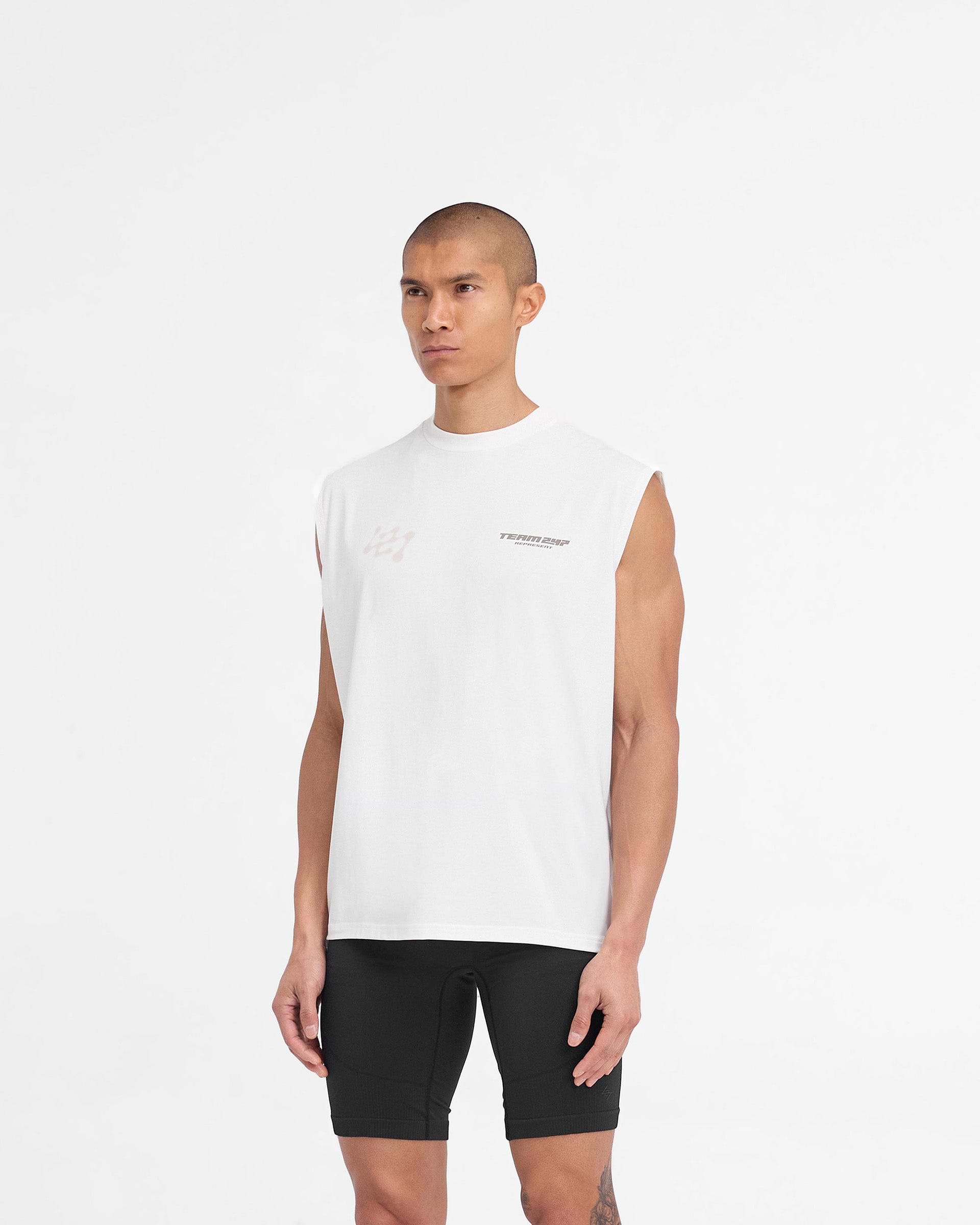 Man wearing an oversized white tank top on a plain white background | 247 Future Terrains Oversized Tank in Flat White | Training tank with quick drying fabric | 247 T-Shirts | Represent Clo