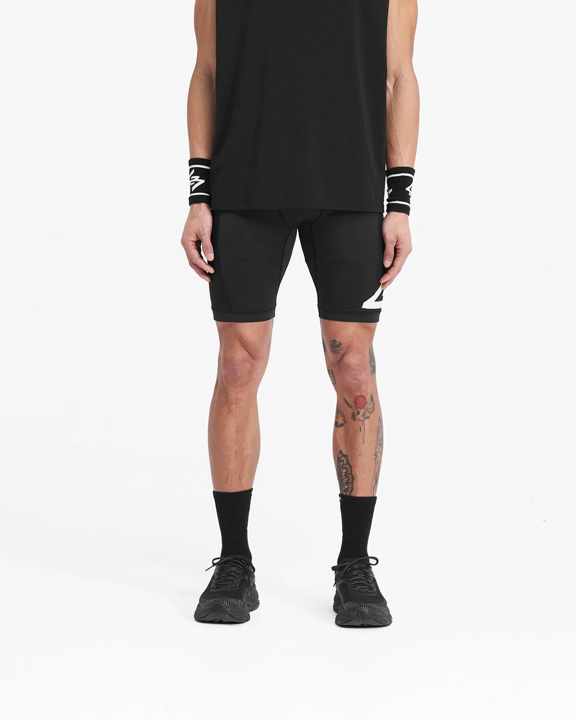 Man wearing jet black cargo half tights on a plain white background | 247 Cargo Half Tight in Jet Black | Shorts with stretch ripstop panels | 247 Shorts | Represent Clo