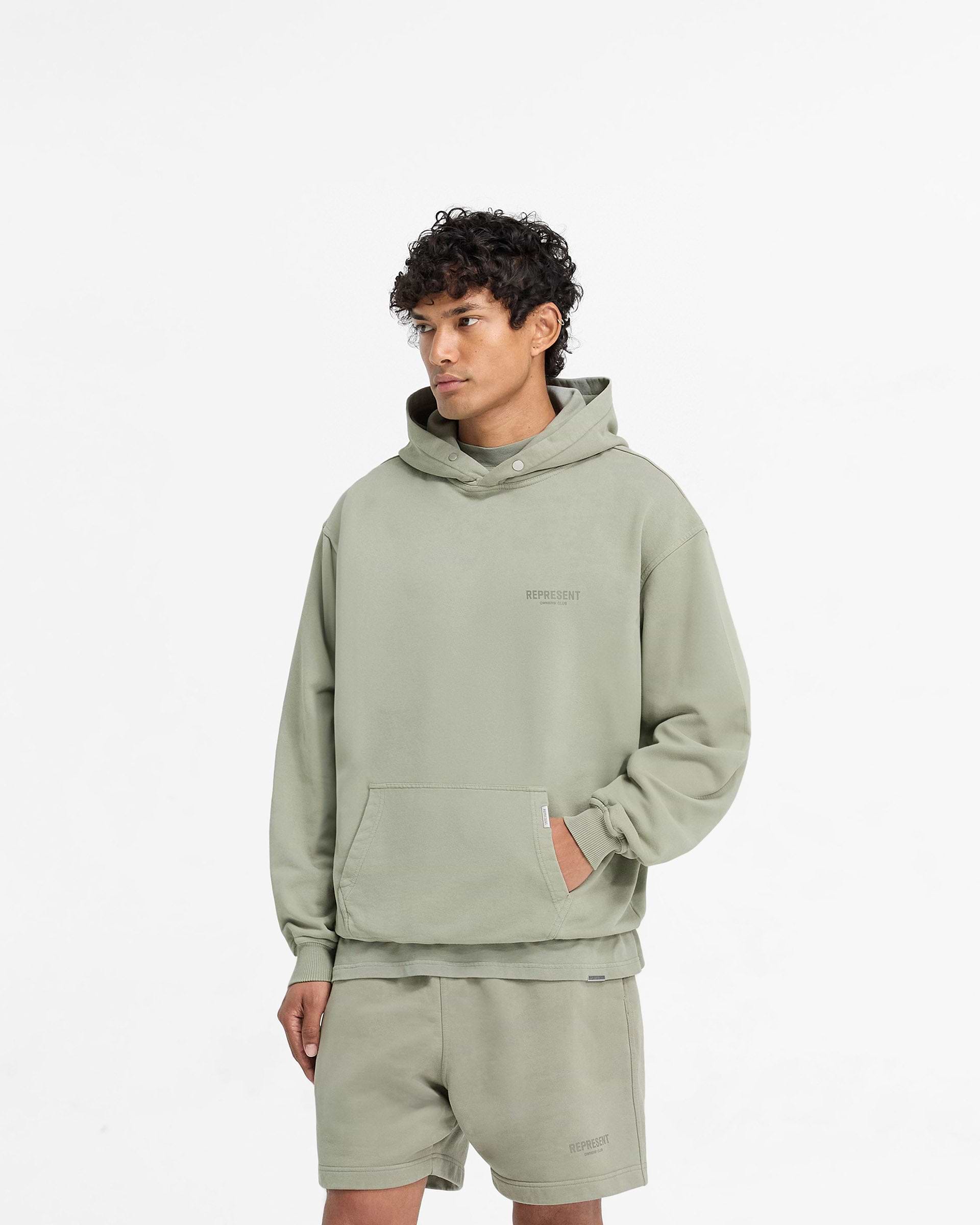 Man wearing a green hoodie on a plain white background | Owners Club Hoodie in Pastel Green | Oversized hoodie with ribbed trims and Cobrax popper | Owners Club Hoodies | Represent Clo