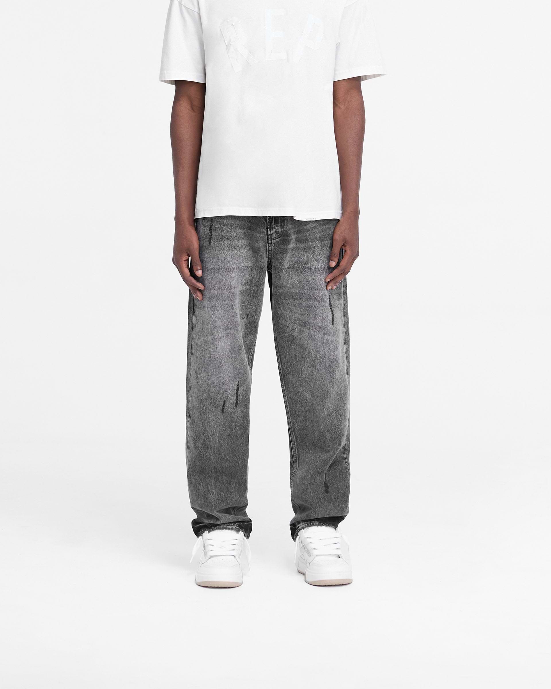 Man wearing grey straight leg jeans on a plain white background | R2 Rep Denim in Charcoal | Denim with fade out wash and whiskering details | FW24 Denim | Represent Clo